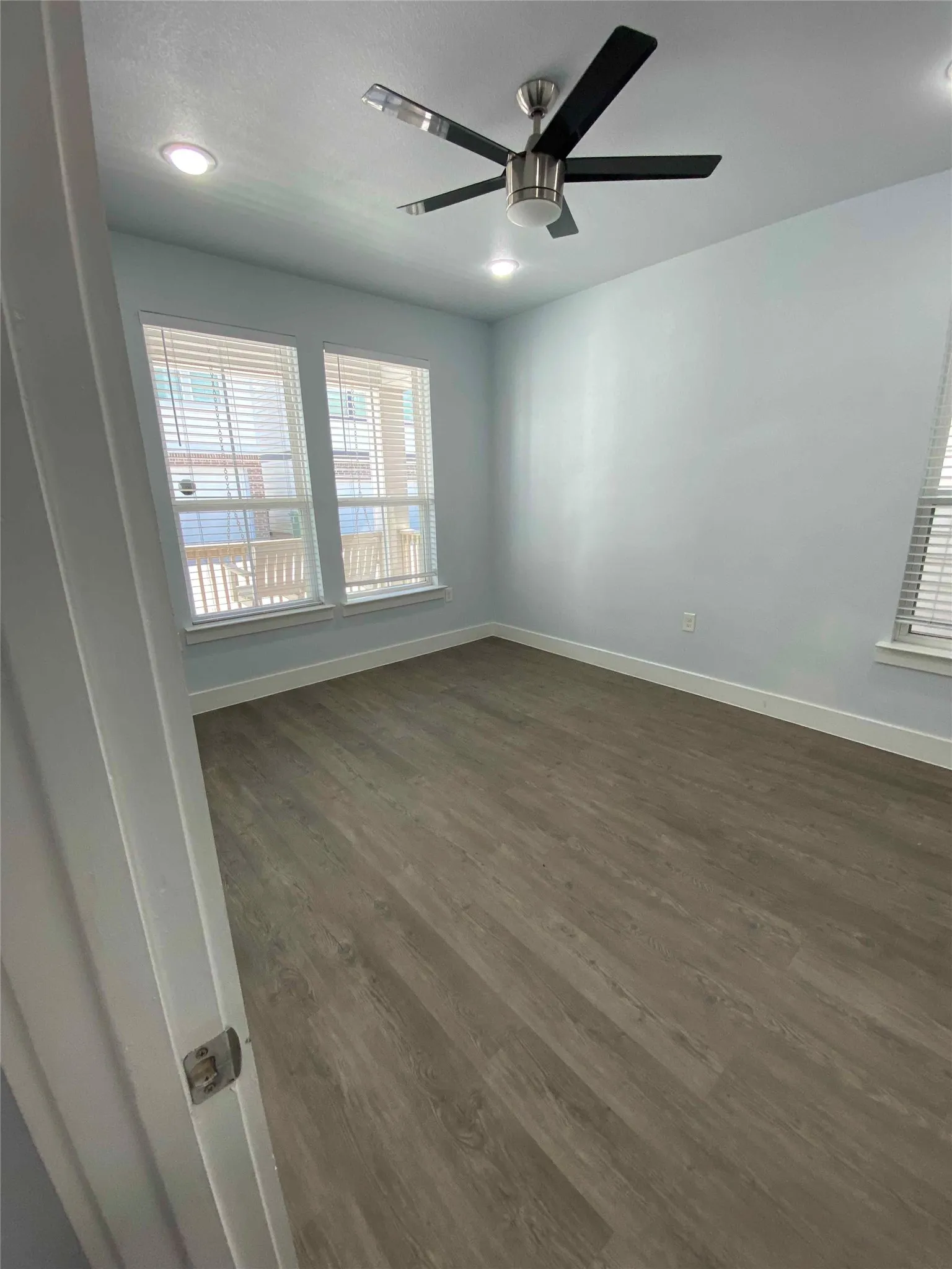 Empty room with dark wood-style floors, a ceiling fan, and recessed lighting