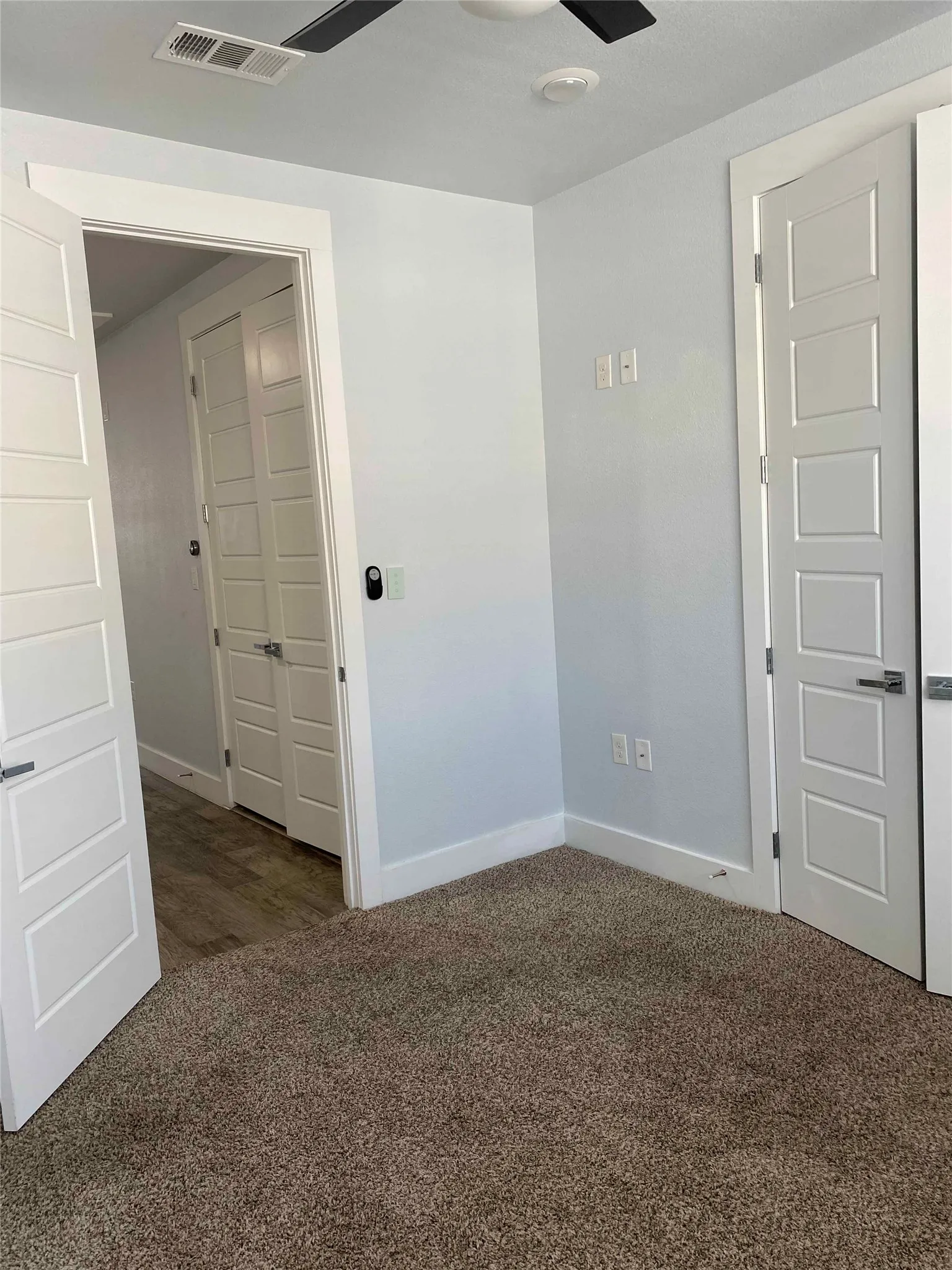 Spare room featuring dark colored carpet and a ceiling fan