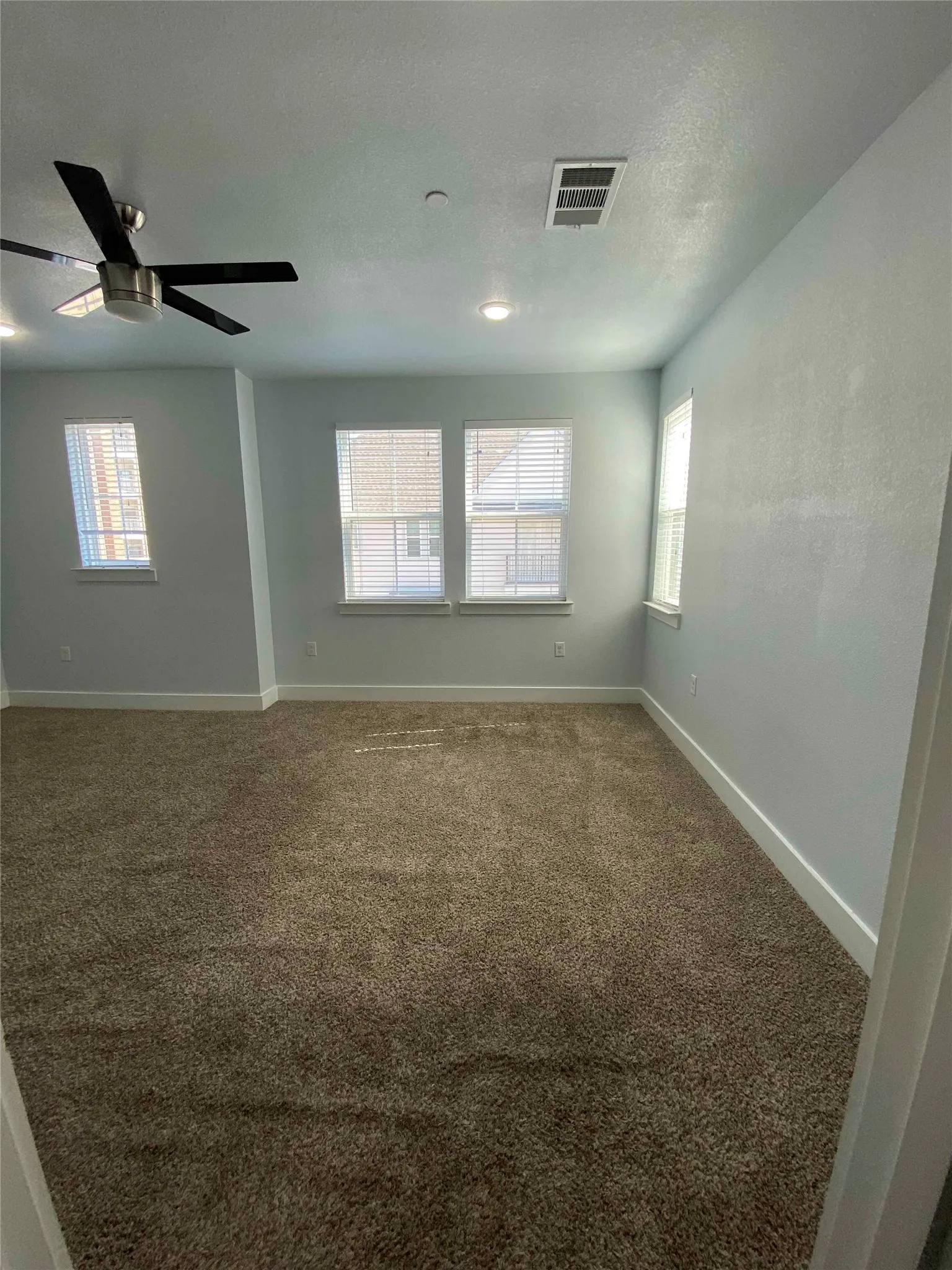 Unfurnished room featuring carpet and a ceiling fan