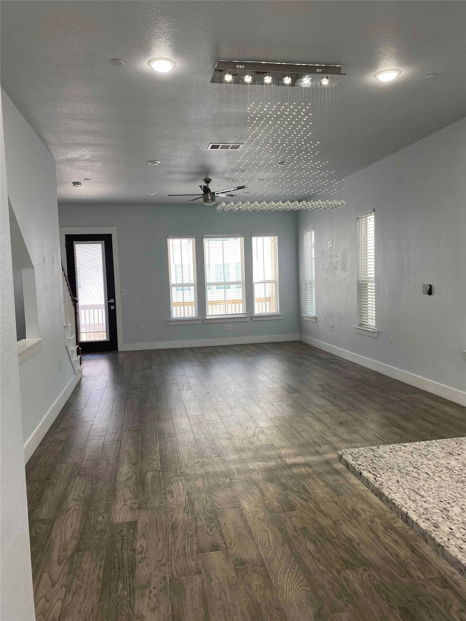 Unfurnished living room featuring a ceiling fan, dark wood-type flooring, healthy amount of natural light, and recessed lighting