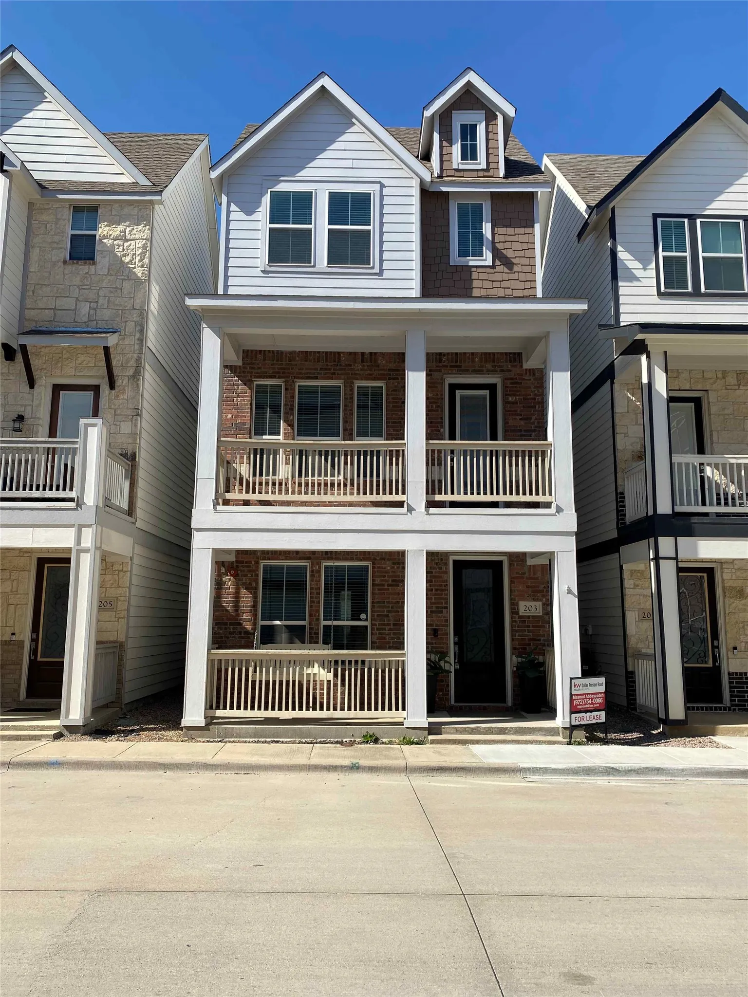 View of front of house featuring brick siding and a balcony