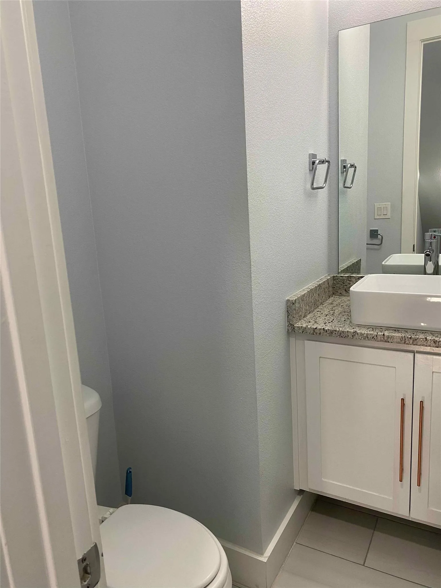 Bathroom featuring vanity, light tile patterned floors, and a textured wall