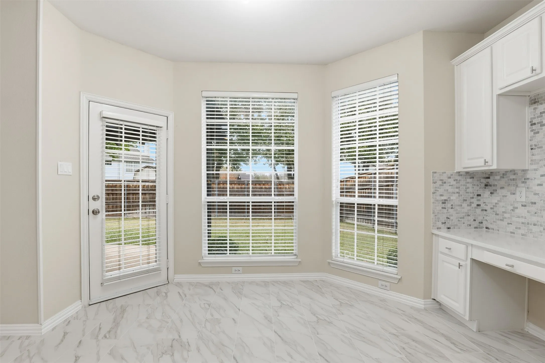 Breakfast nook with large windows and view of the backyard