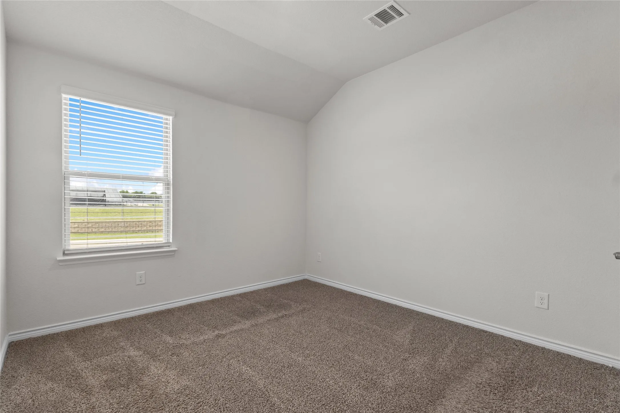 Unfurnished room with lofted ceiling, carpet, and baseboards