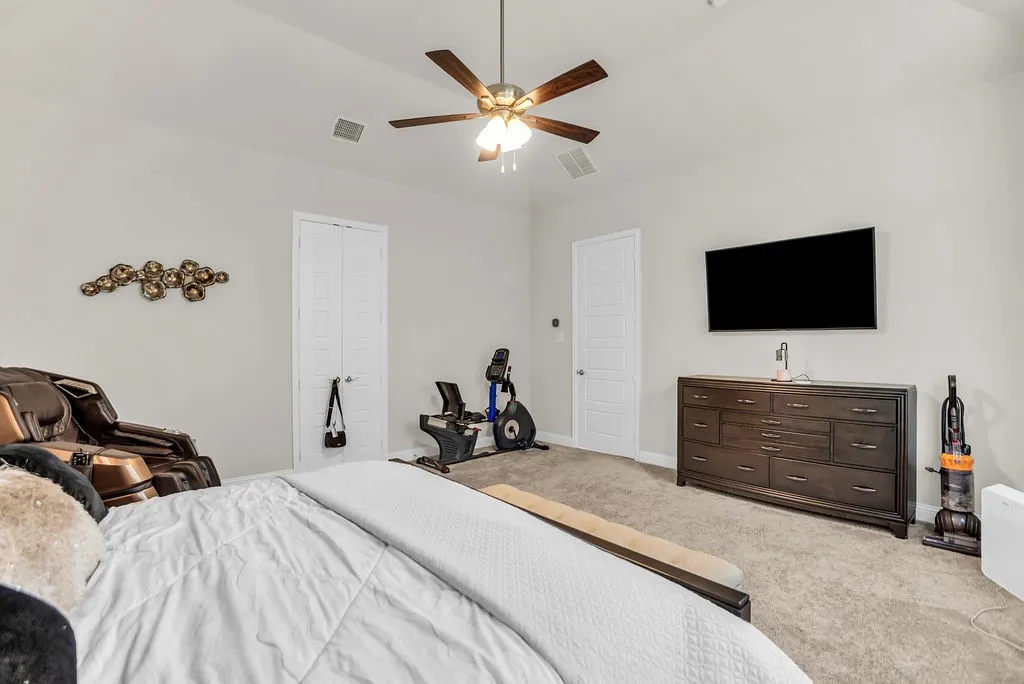 Vaulted ceiling with a ceiling fan, light gray wall paint, and two paneled interior doors