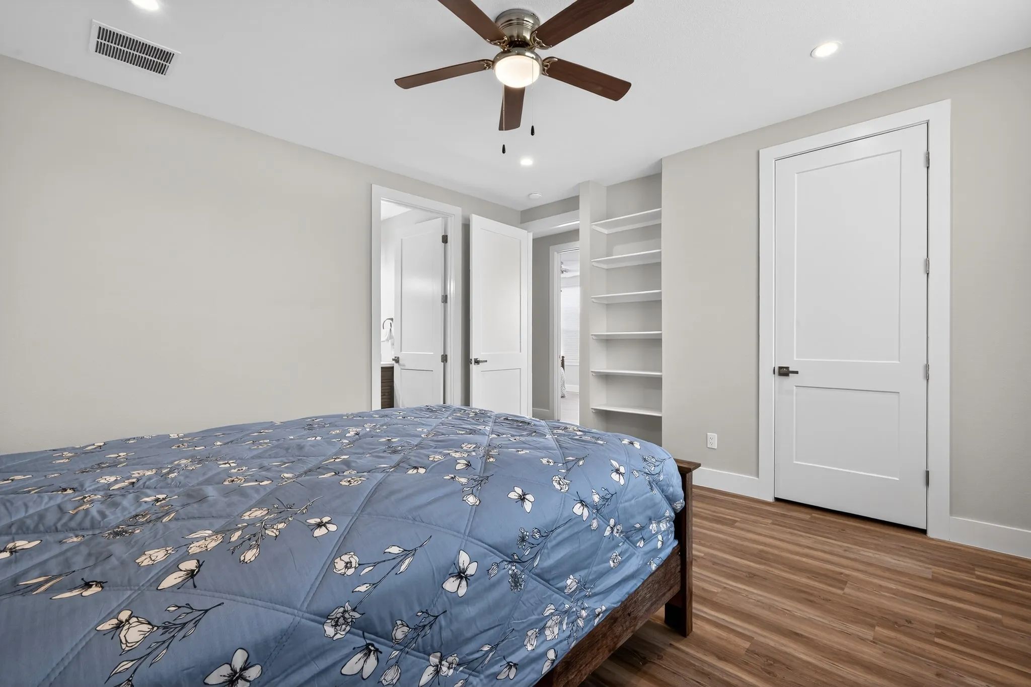 Wood-finish flooring, recessed lighting, and a ceiling fan with integrated lighting