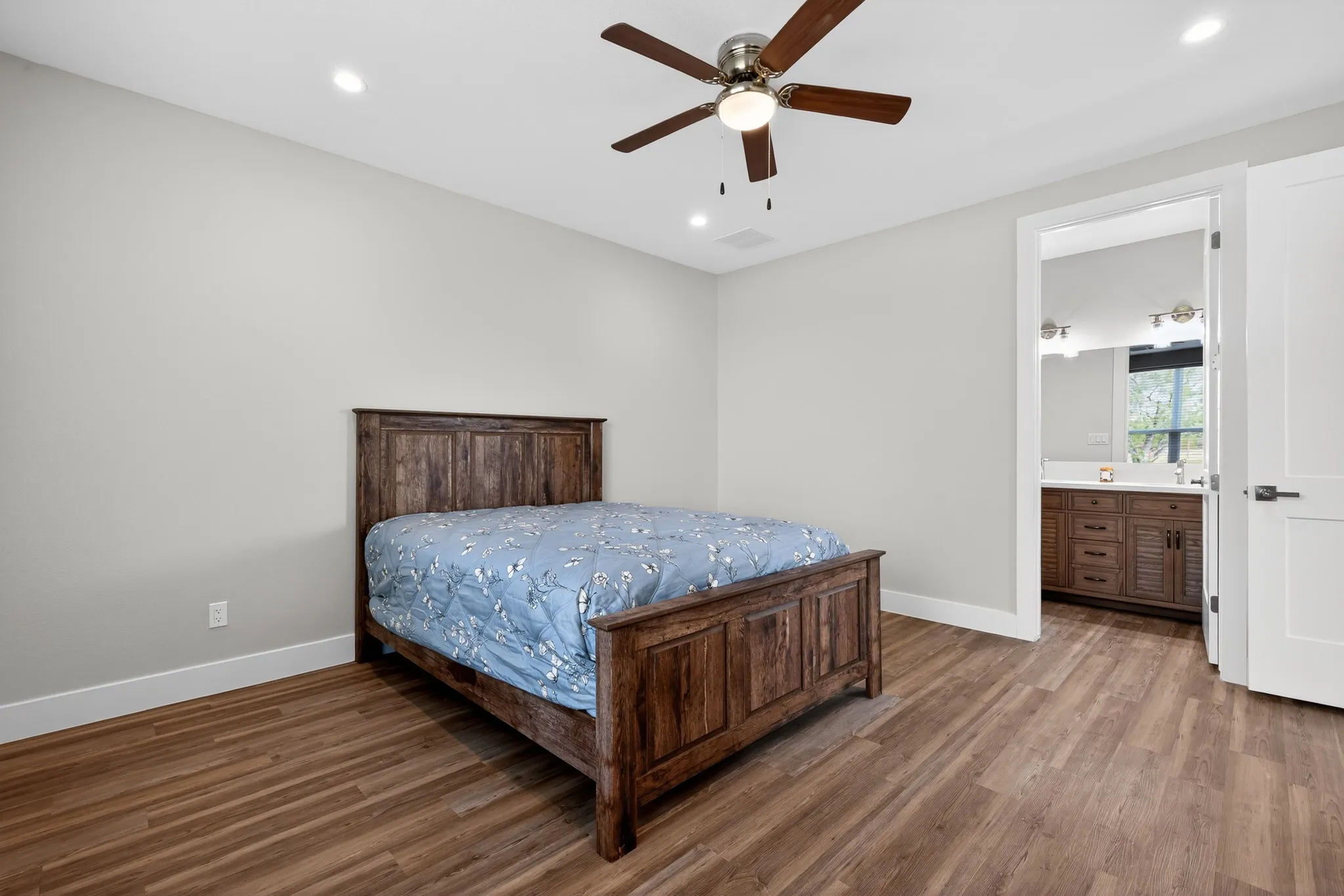 Wood-finish flooring, recessed lighting, and a ceiling fan with integrated lighting