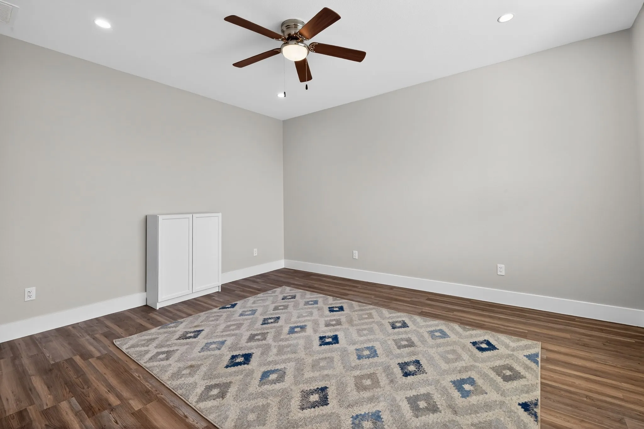 Wood-finish flooring, recessed lighting, and a ceiling fan with integrated light fixture