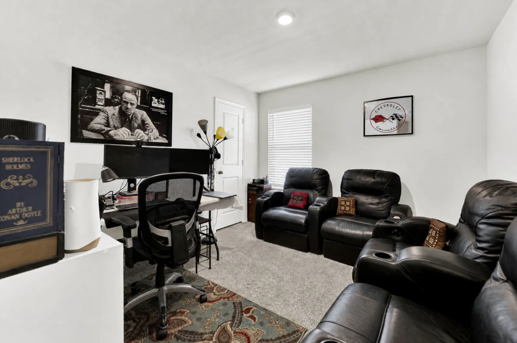 Soft carpeting, bright overhead lighting, and a crisp window bring flexibility to this secondary bedroom, currently styled as a media lounge and home office. It provides an ideal space for remote work setups, gaming, or a quiet hobby room.