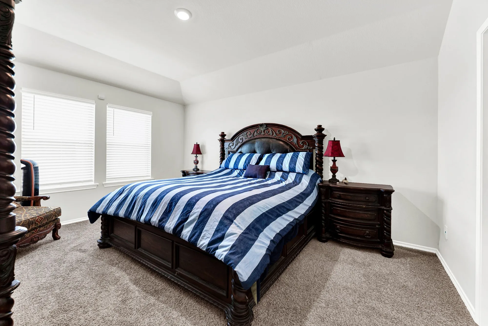Plush carpeting and soft neutral walls define this peaceful primary retreat, anchored by two bright windows that let in gentle morning light. It offers a relaxing sanctuary where you can unwind and recharge at the end of a long day.