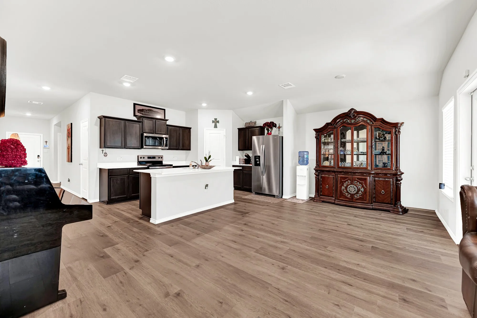 This flexible dining zone flows seamlessly into the main kitchen island and central hallway, anchored by soft neutral walls and warm wood-look tones. You will love how easily guests can mingle between the dining table and kitchen during holiday celebrations.