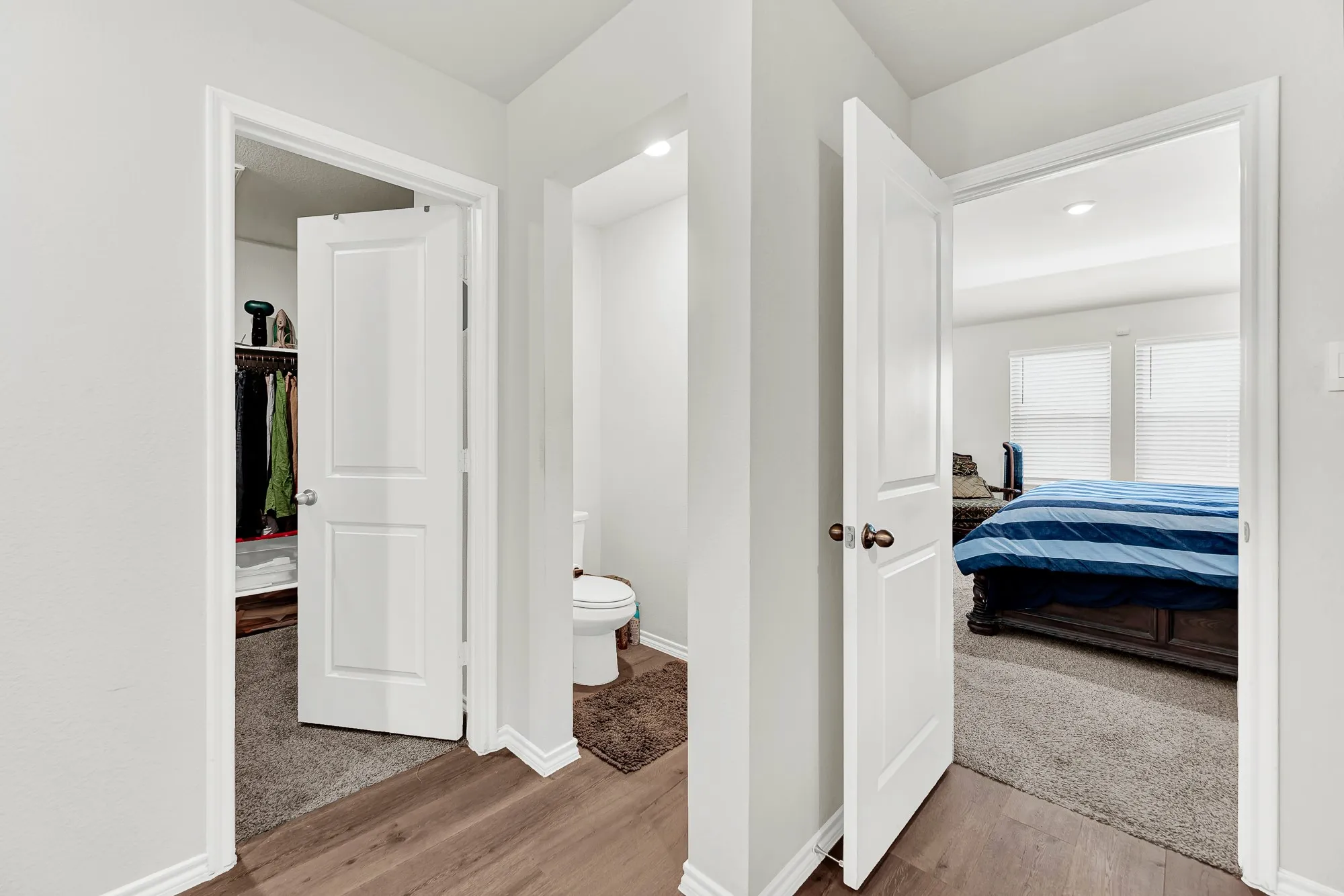 This functional bathroom layout includes a private water closet nook and direct entry to a generous walk-in closet right off the bedroom entrance. It offers a well-designed setup that makes getting ready in the morning seamless and stress-free.