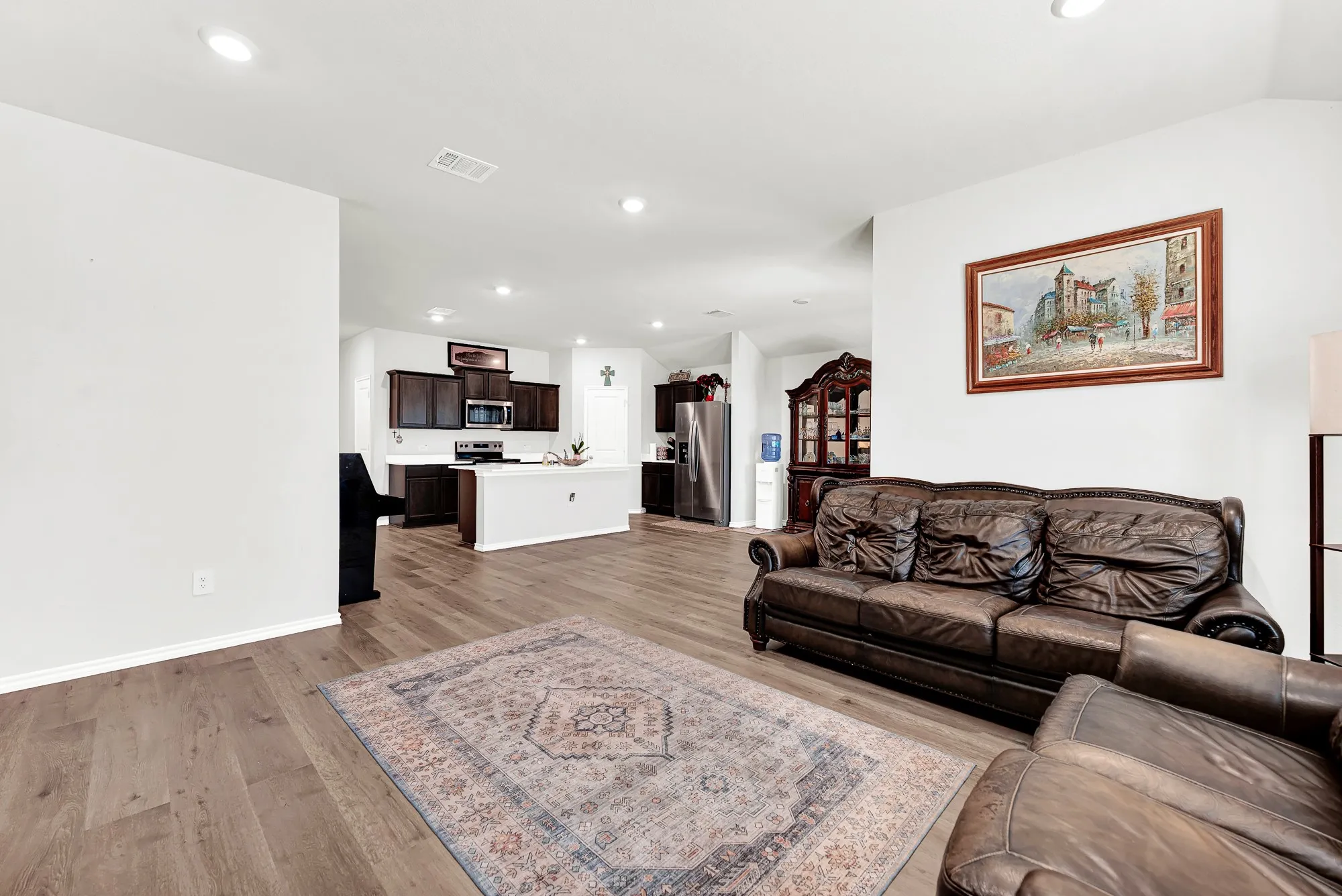 This spacious family room opens directly to the central kitchen island, creating an effortless layout that connects both primary living areas. Preparing snacks in the kitchen while staying part of the conversation in the main room is completely seamless.