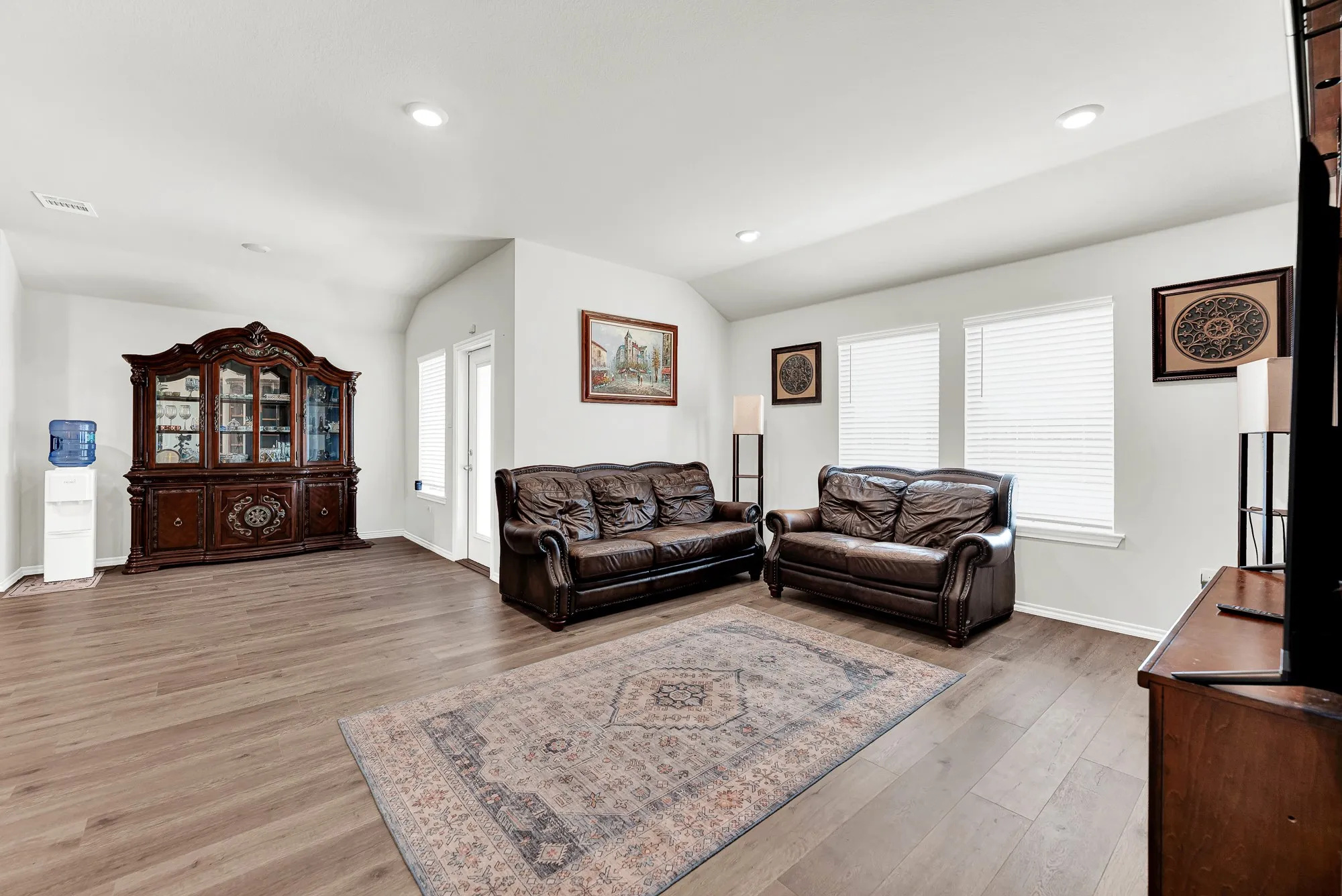 Generous floor space and clean sightlines toward the glass patio door give this central gathering space a bright, airy feeling. Whether hosting weekend gatherings or enjoying quiet evenings, this space easily adapts to your daily lifestyle.