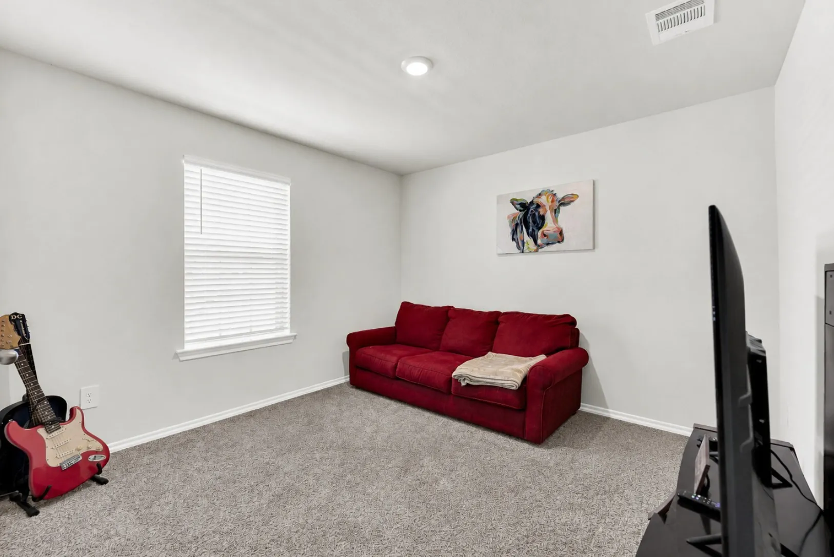 Another spacious secondary bedroom features a clean single-window design, light neutral palette, and soft carpeting. Its versatile footprint easily adapts to a guest suite, exercise room, or creative space to suit your needs.