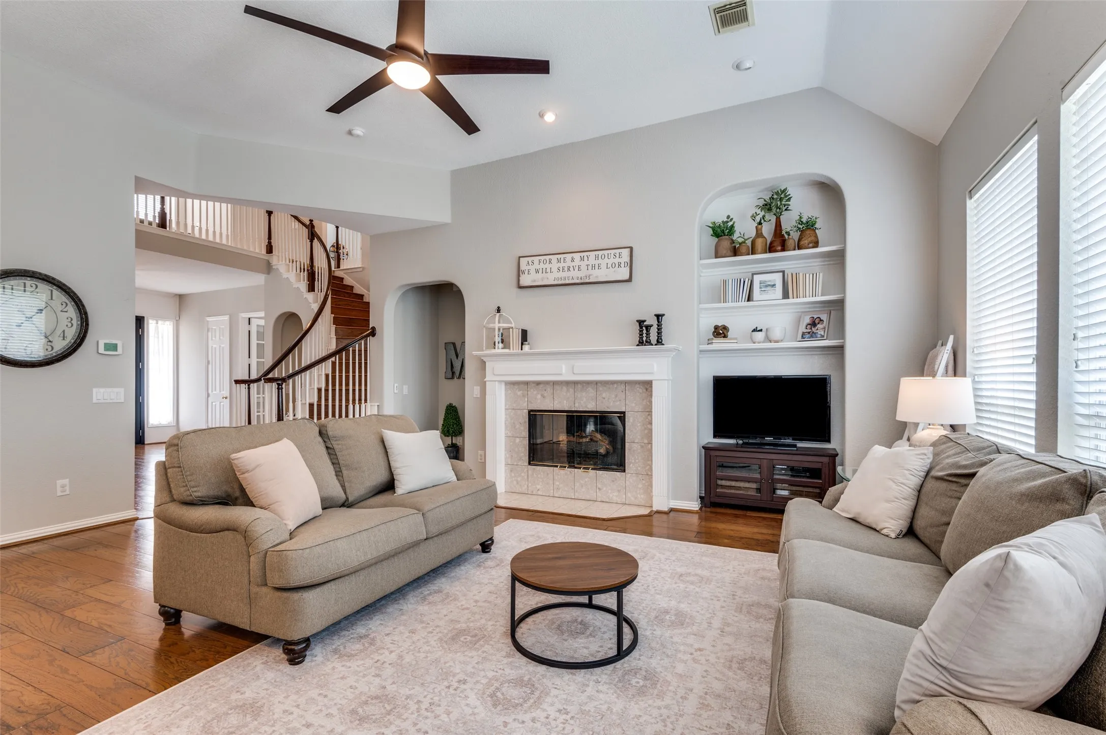 Cozy, open living room with fireplace, built-ins, and an abundance of windows