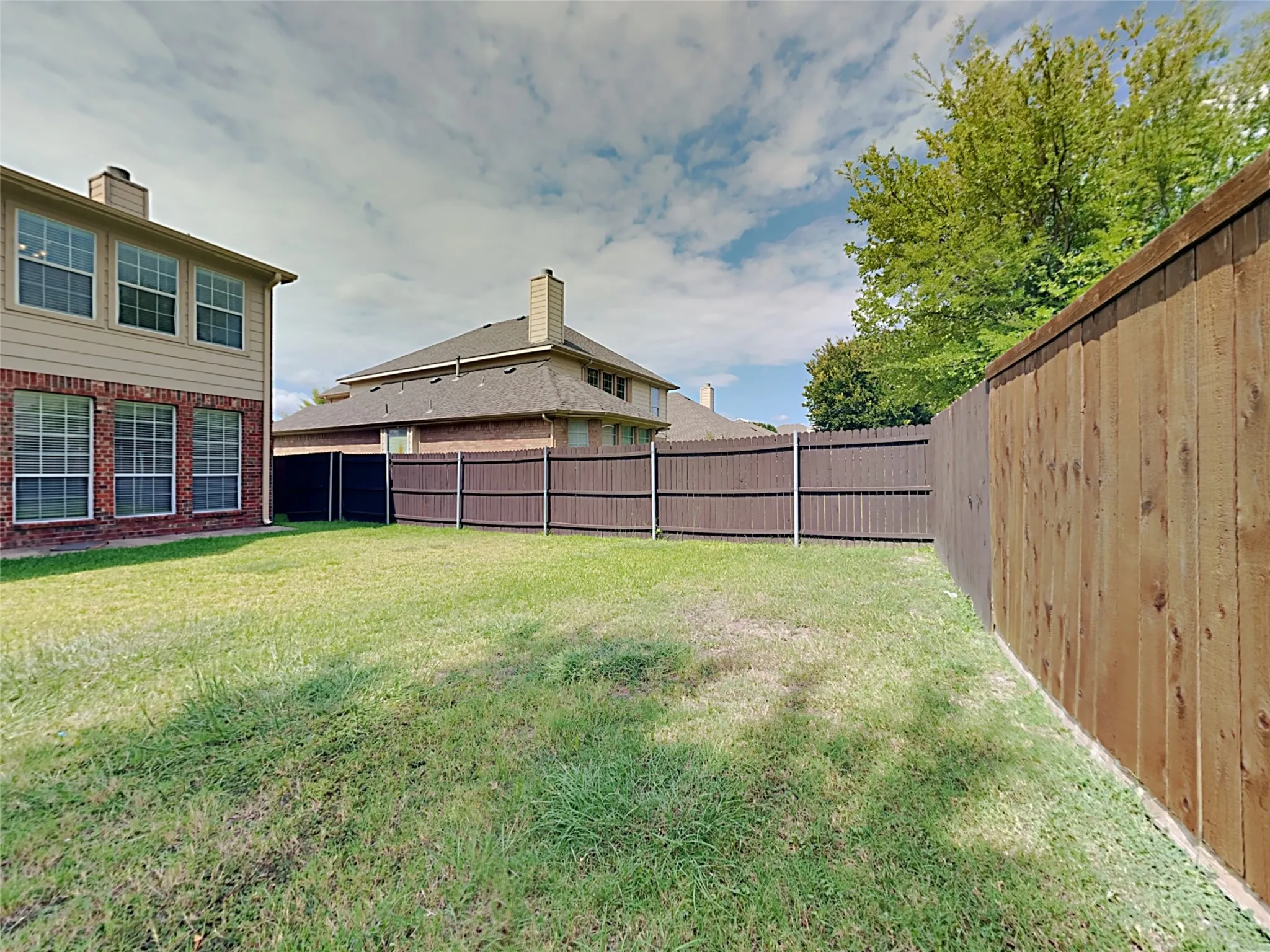 Expansive grassy yard with wood fencing