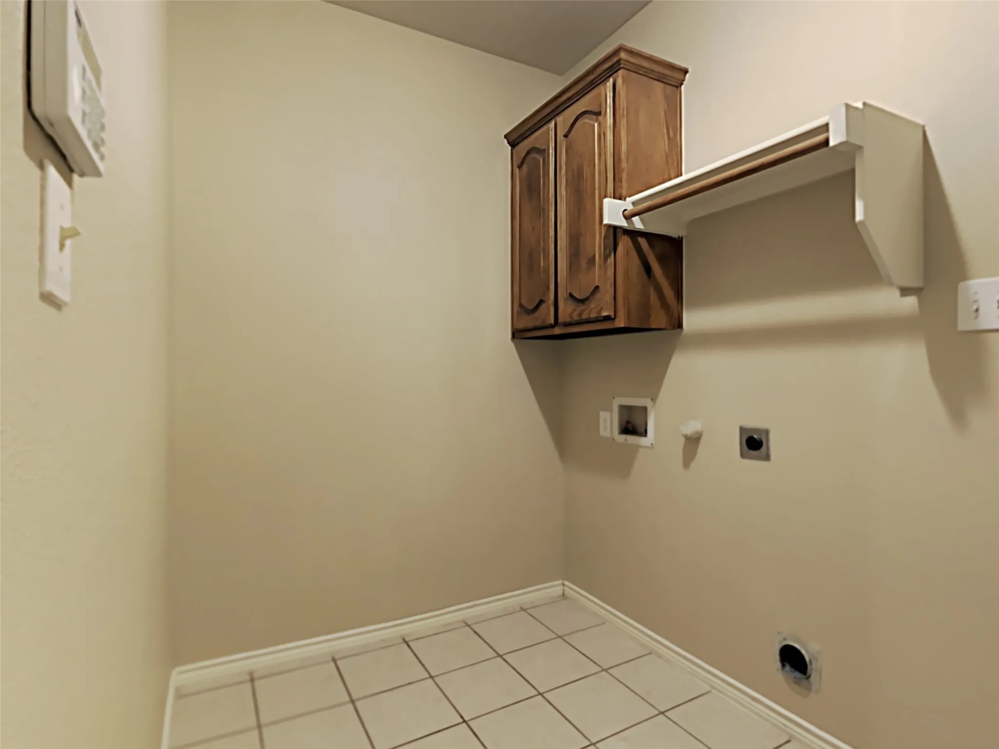 Tile flooring, wood-finish cabinetry, and a built-in hanging rack