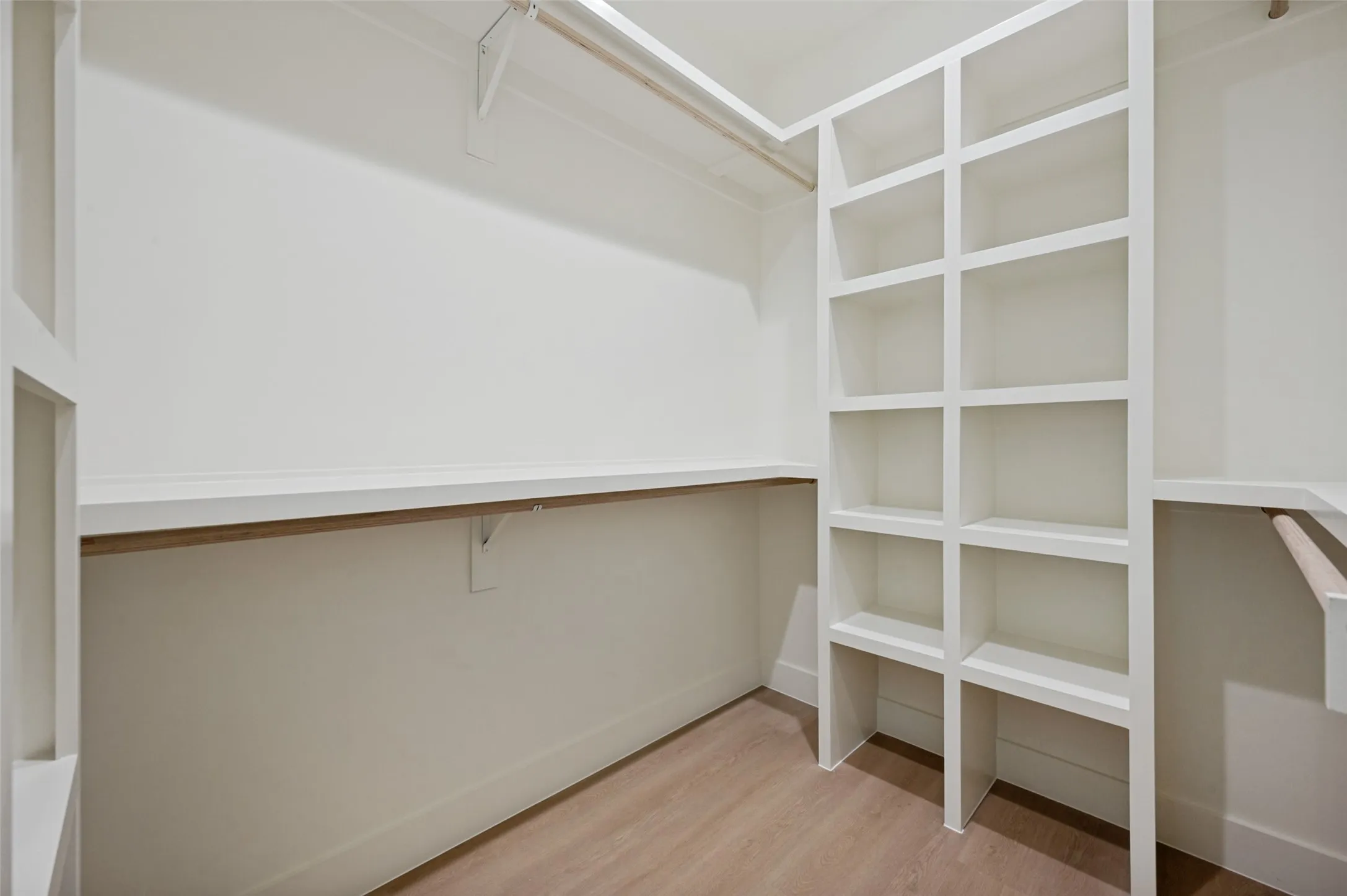 Custom built-in shelving, wood-finish flooring, and white painted walls