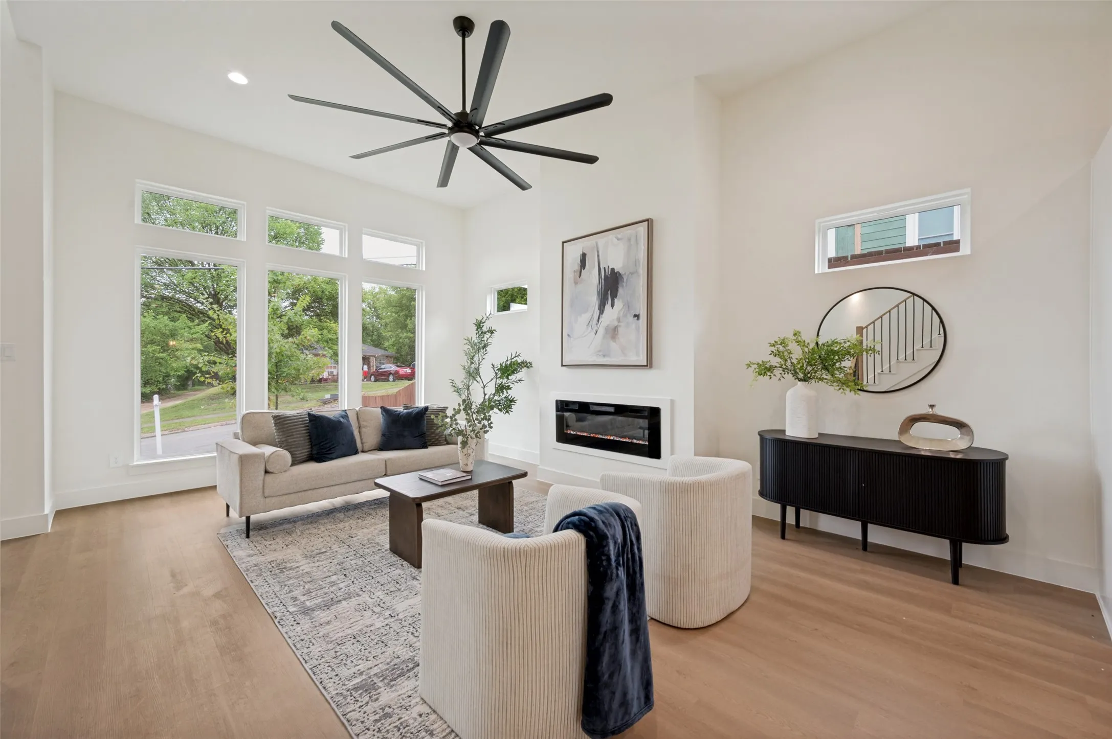 Vaulted ceiling, wood-finish flooring, large windows, recessed lighting, and a built-in fireplace