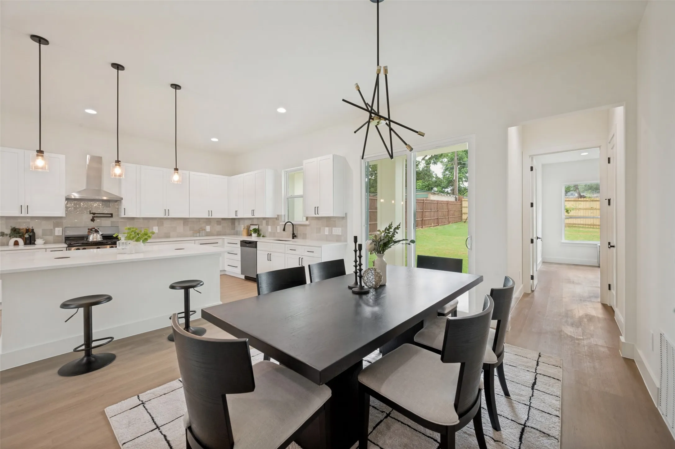 Kitchen featuring white cabinetry, stainless steel appliances, a center island with seating, and a tile backsplash