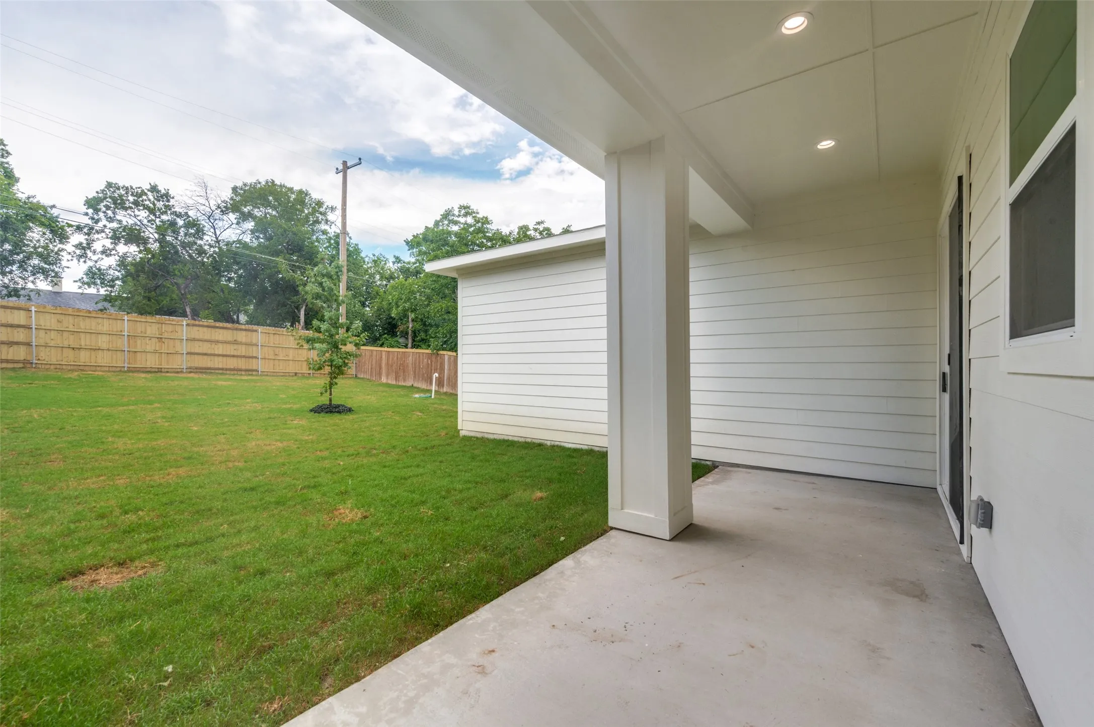 Covered concrete patio with recessed lighting, shiplap siding, and a sliding glass door