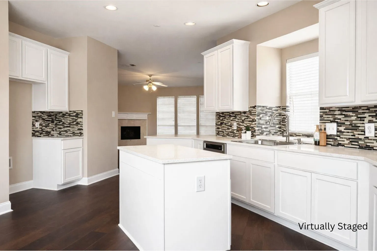 Kitchen featuring white cabinetry, a central island, mosaic tile backsplash, stainless steel sink, and dark wood-finish flooring