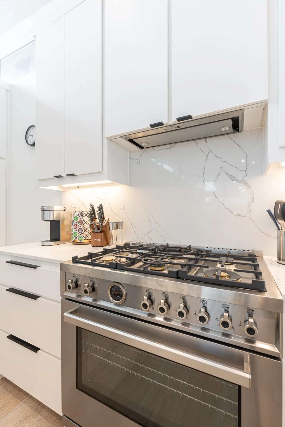 Kitchen featuring high end range, white cabinets, and decorative backsplash
