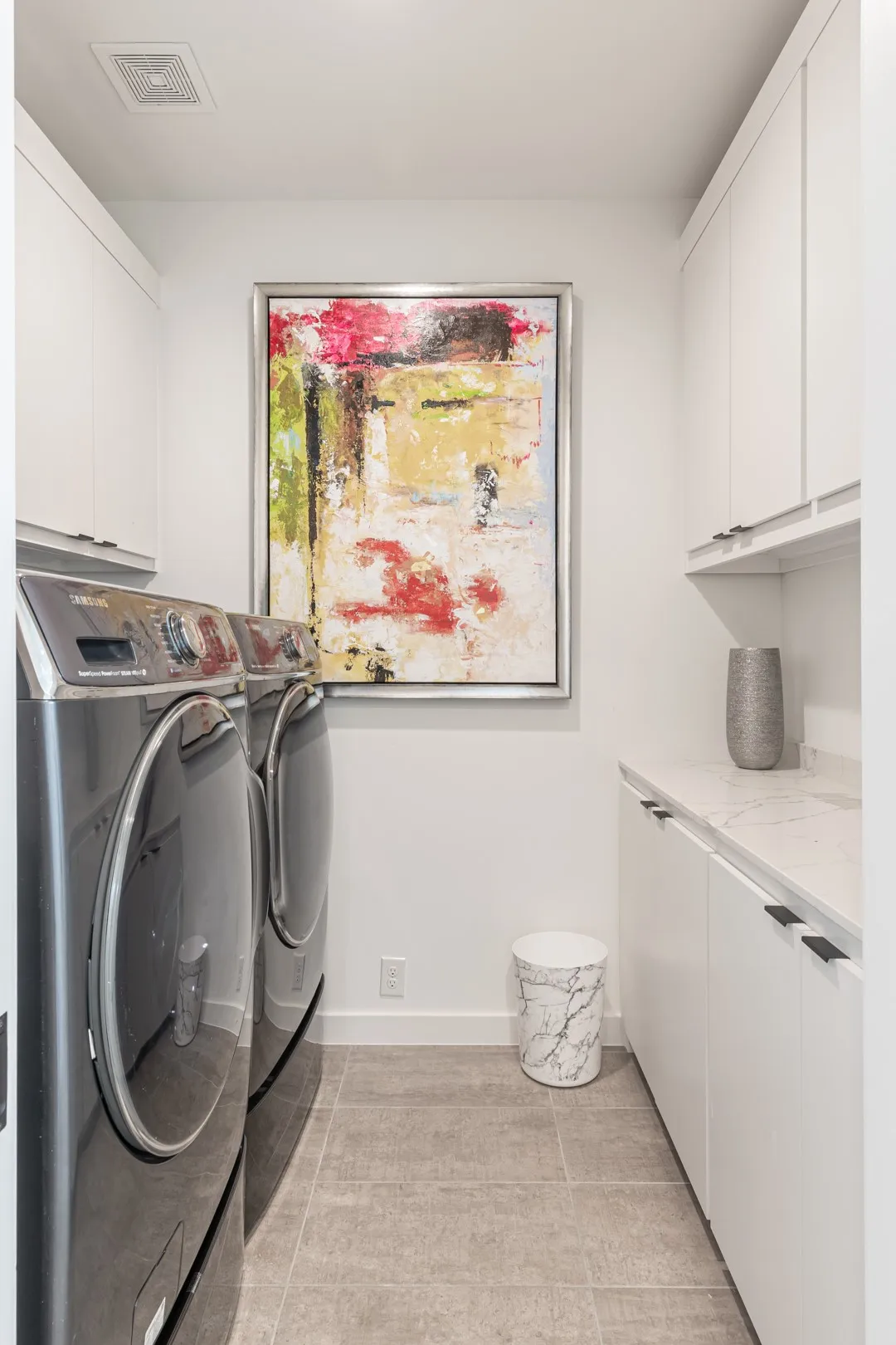 Washroom featuring cabinet space, independent washer and dryer, and light tile patterned floors