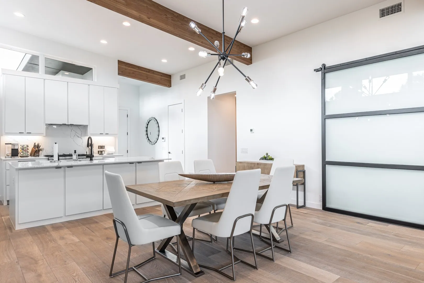 Dining room featuring beam ceiling, recessed lighting, light wood-type flooring, and a chandelier