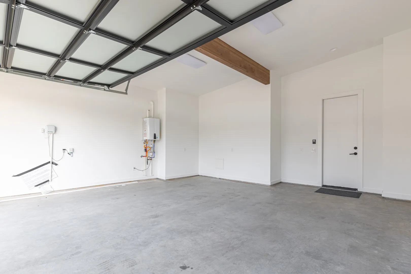 Garage with baseboards and tankless water heater