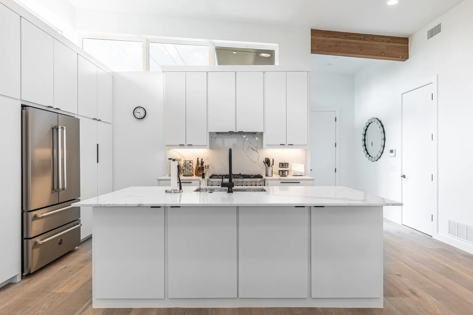 Kitchen with high quality fridge, white cabinetry, recessed lighting, light wood-style floors, and beamed ceiling