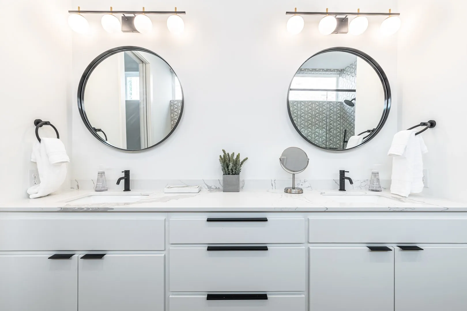 Full bath with double vanity, plenty of natural light, and a​​‌​​​​‌​​‌‌​‌‌​​​‌‌​‌​‌​‌​​​‌​​ shower