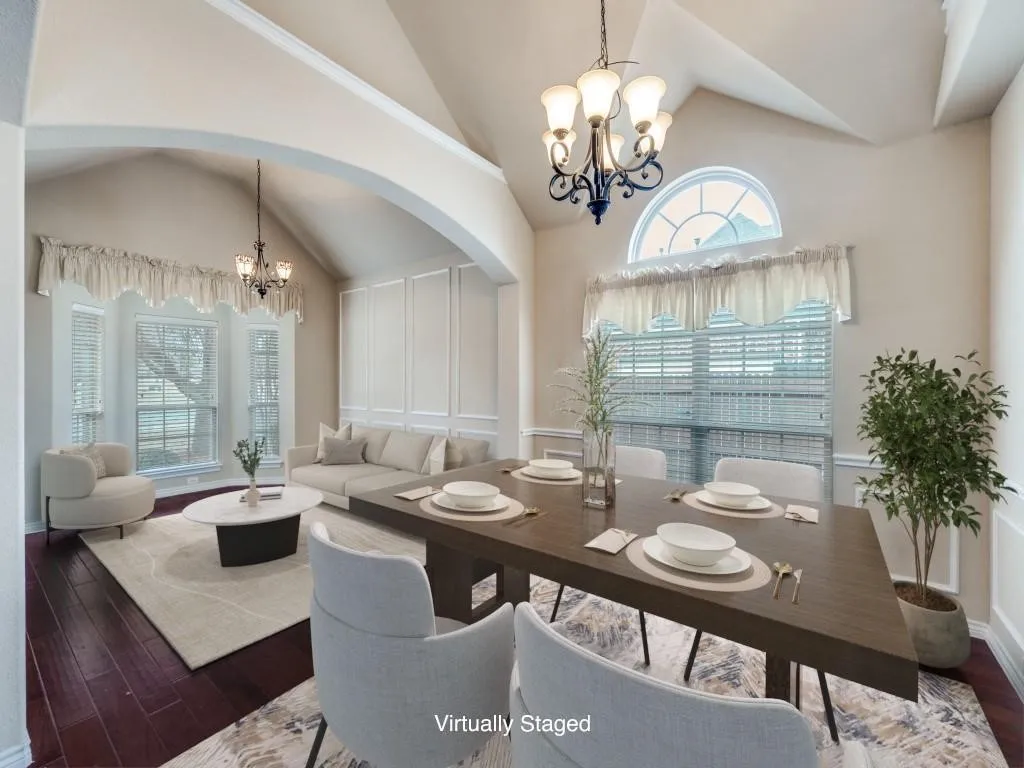 Vaulted ceilings, wood-finish flooring, decorative wall paneling, arched entryways, and a large arched window