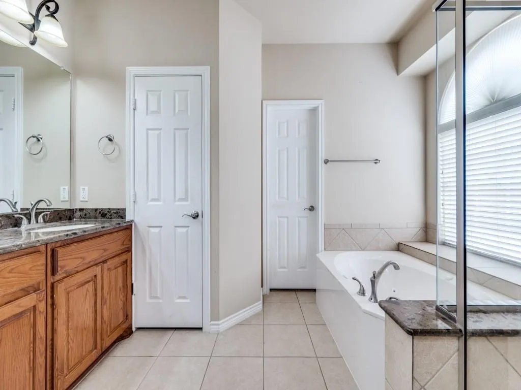 Dual vanity with wood-finish cabinetry and stone countertops