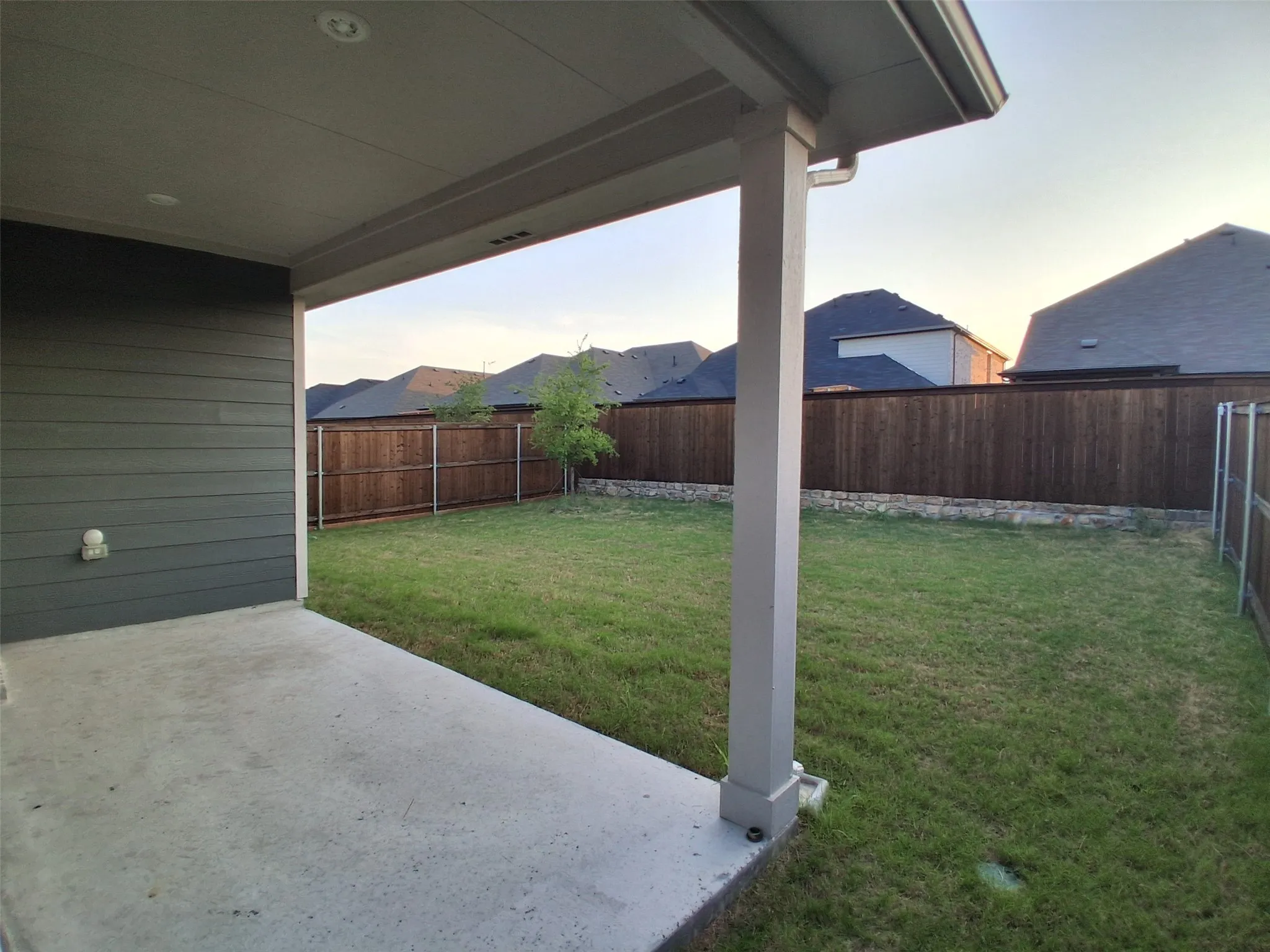 Covered concrete patio with expansive yard for your enjoyment!
