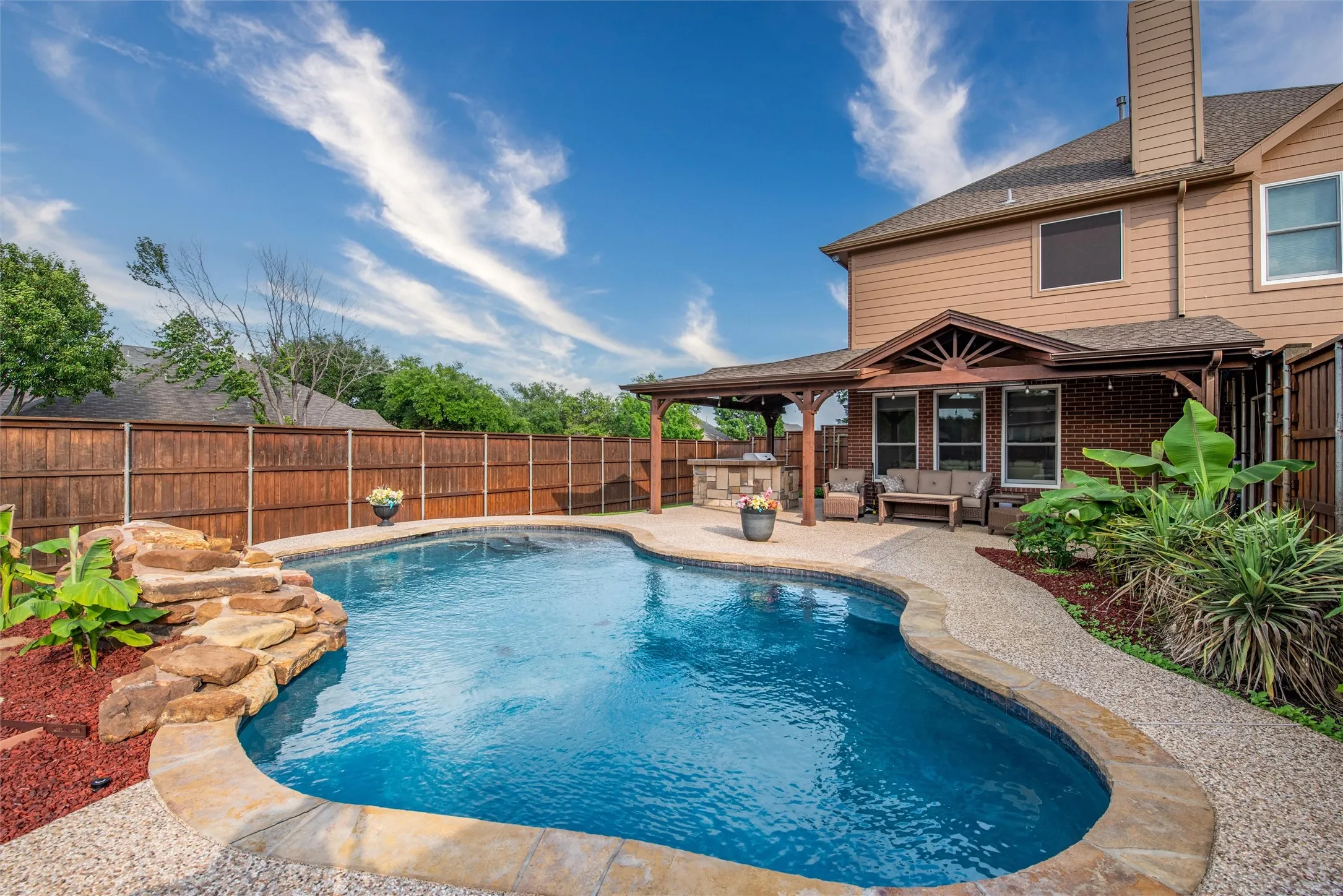 Your backyard space with a pool, covered patio and built-in kitchen.