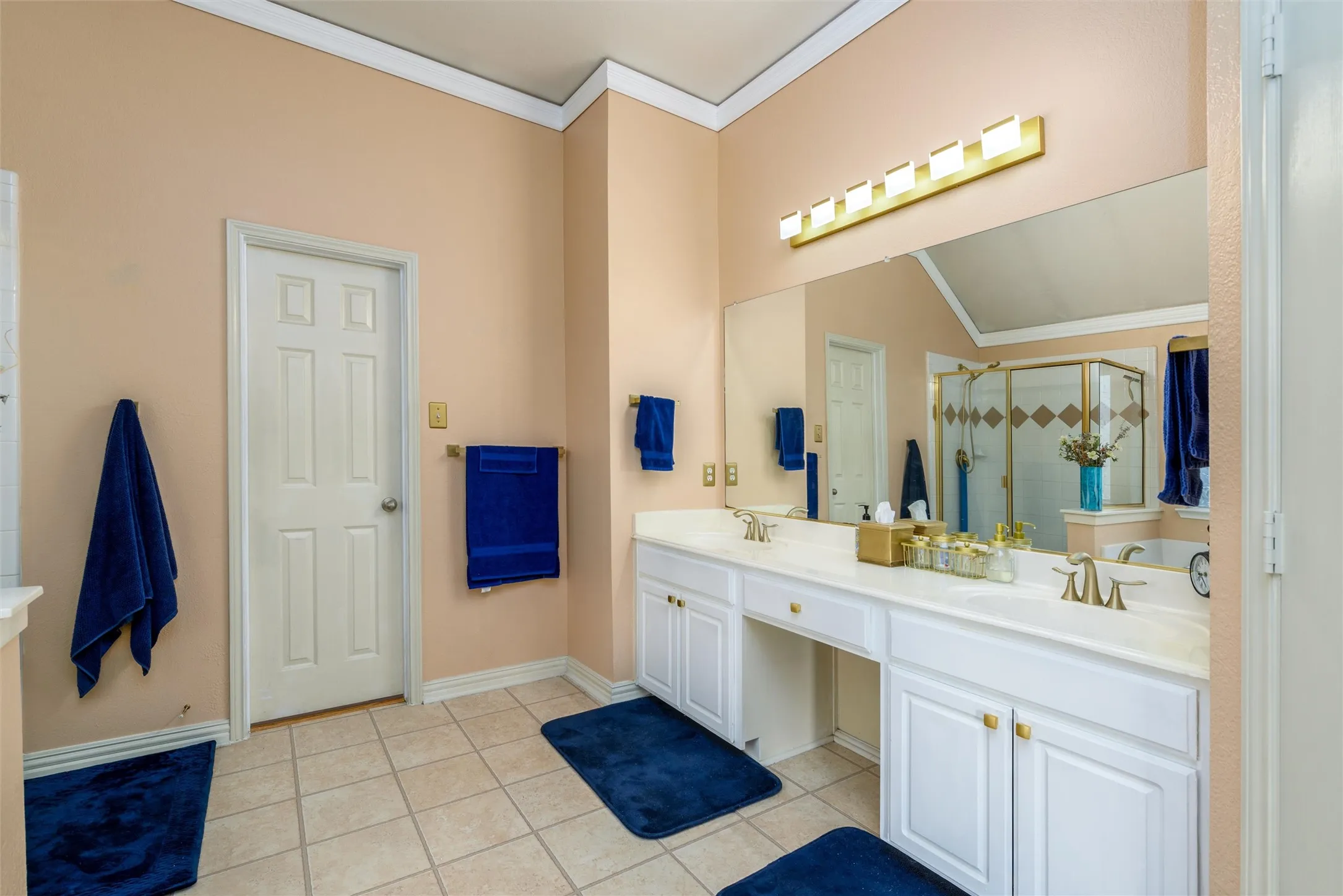 An ensuite primary bath with dual sinks and separate shower and whirlpool bath.