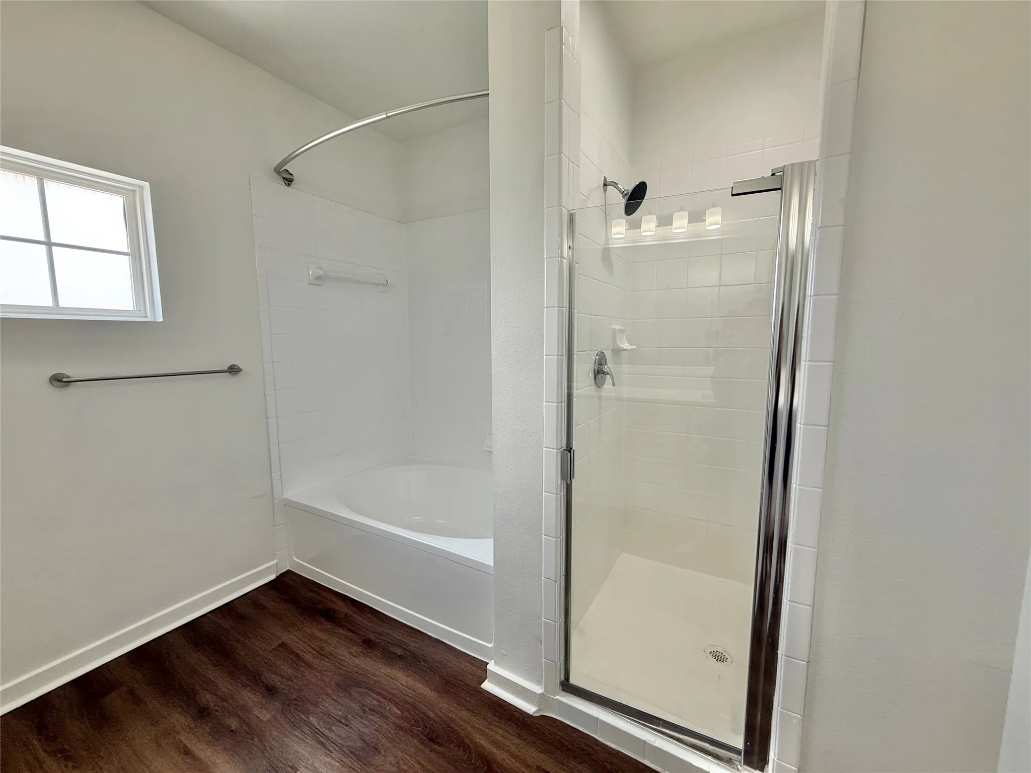 Full bathroom featuring wood finished floors and baseboards