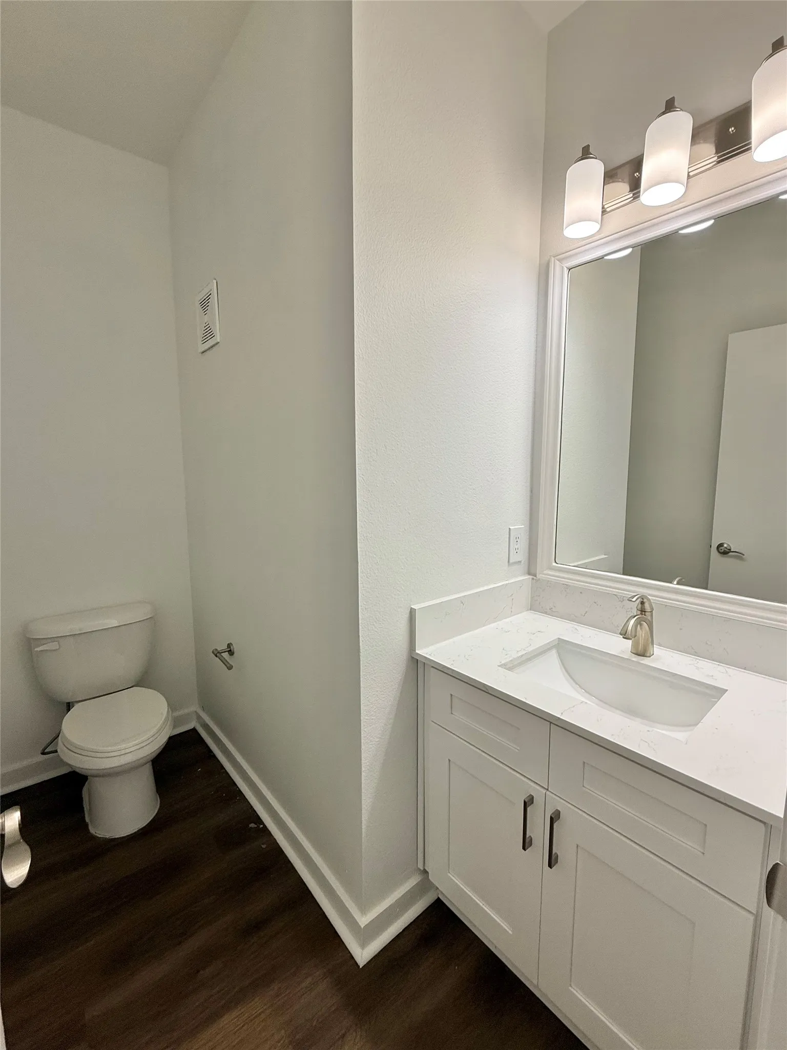 Bathroom featuring wood finished floors, toilet, vanity, and​​‌​​​​‌​​‌‌​‌‌​​​‌‌​‌​‌​‌​​​‌​​ baseboards