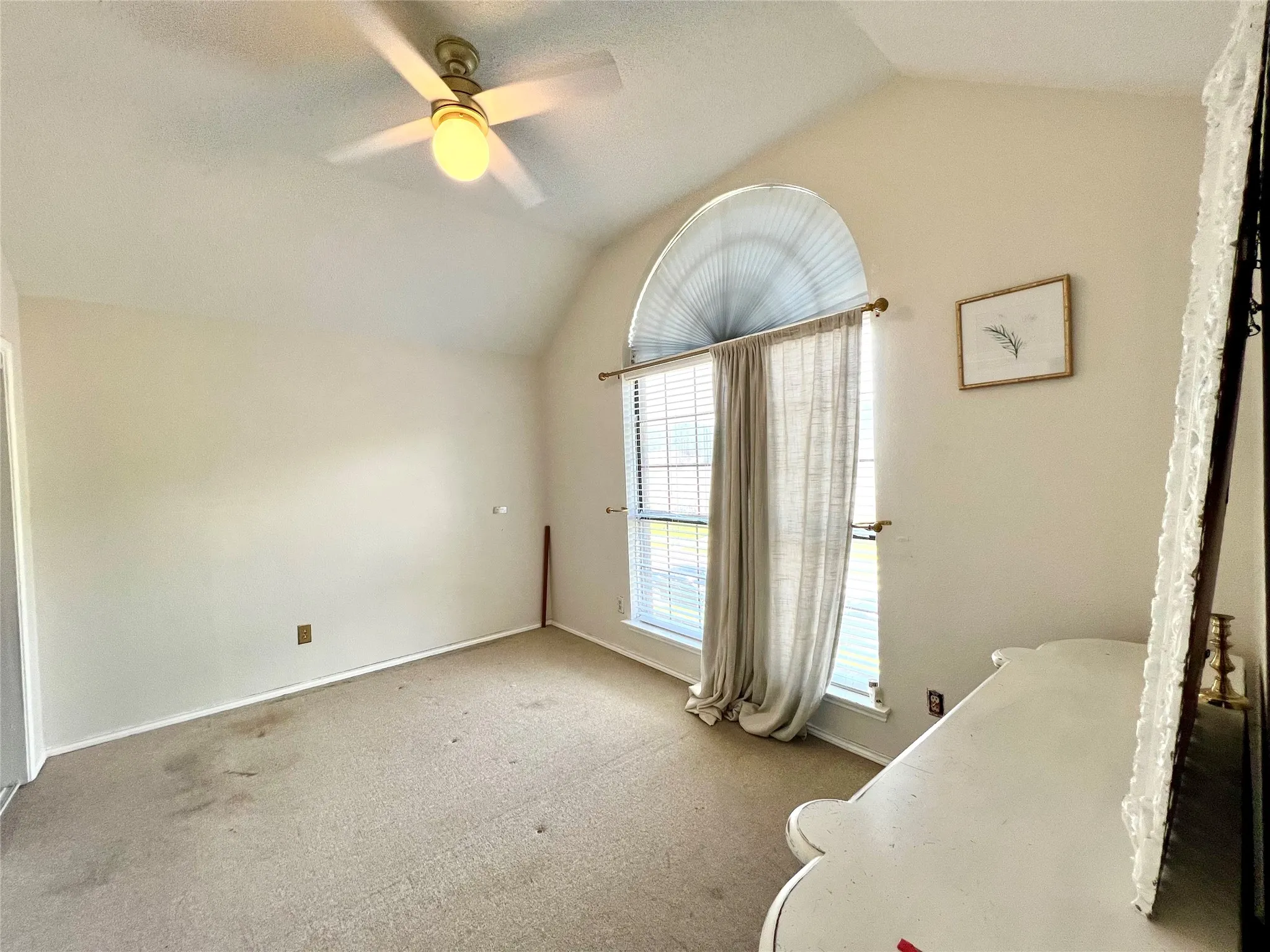 Unfurnished bedroom featuring lofted ceiling, carpet flooring, and ceiling fan