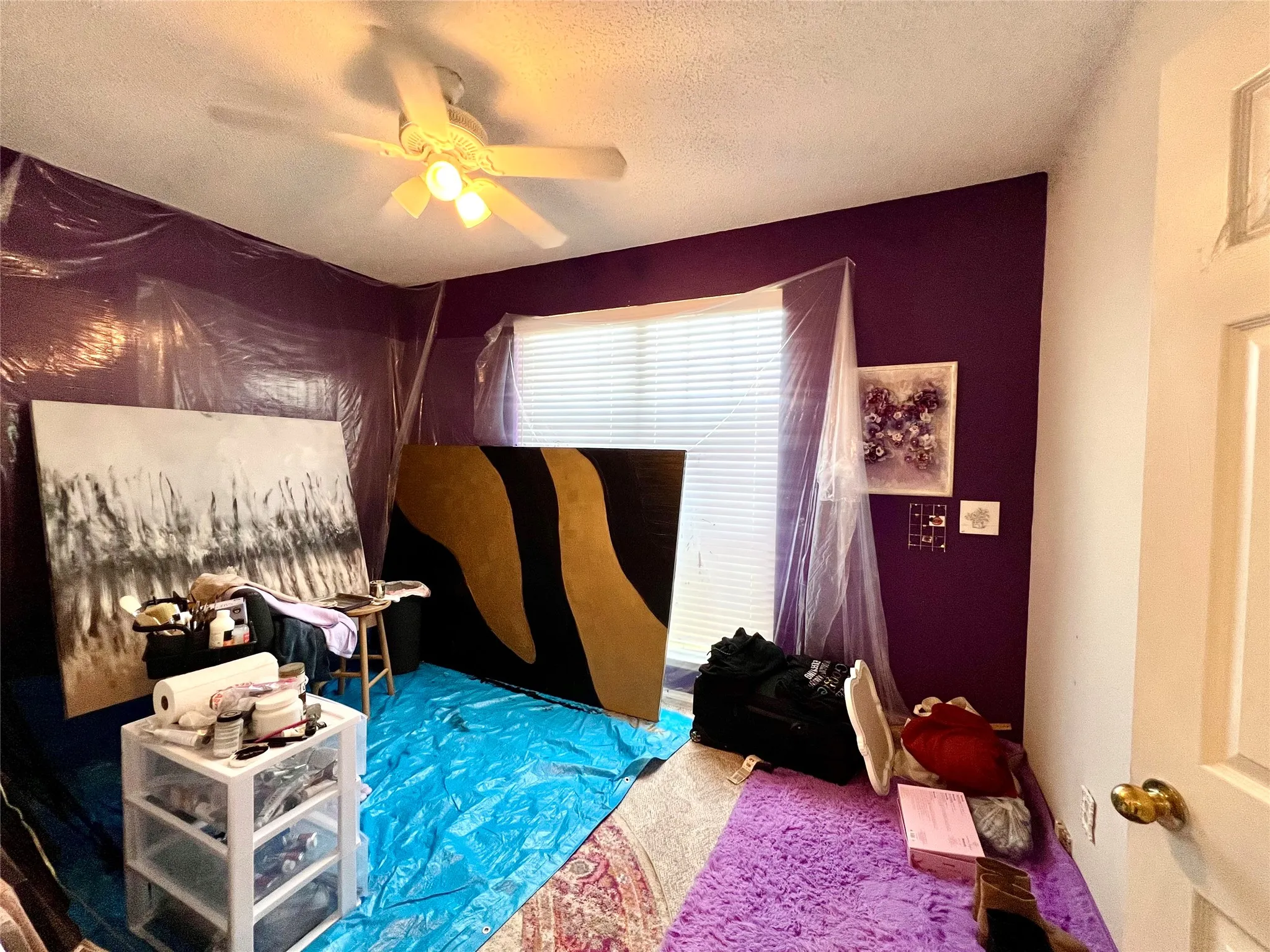 Bedroom with a textured ceiling and a ceiling fan