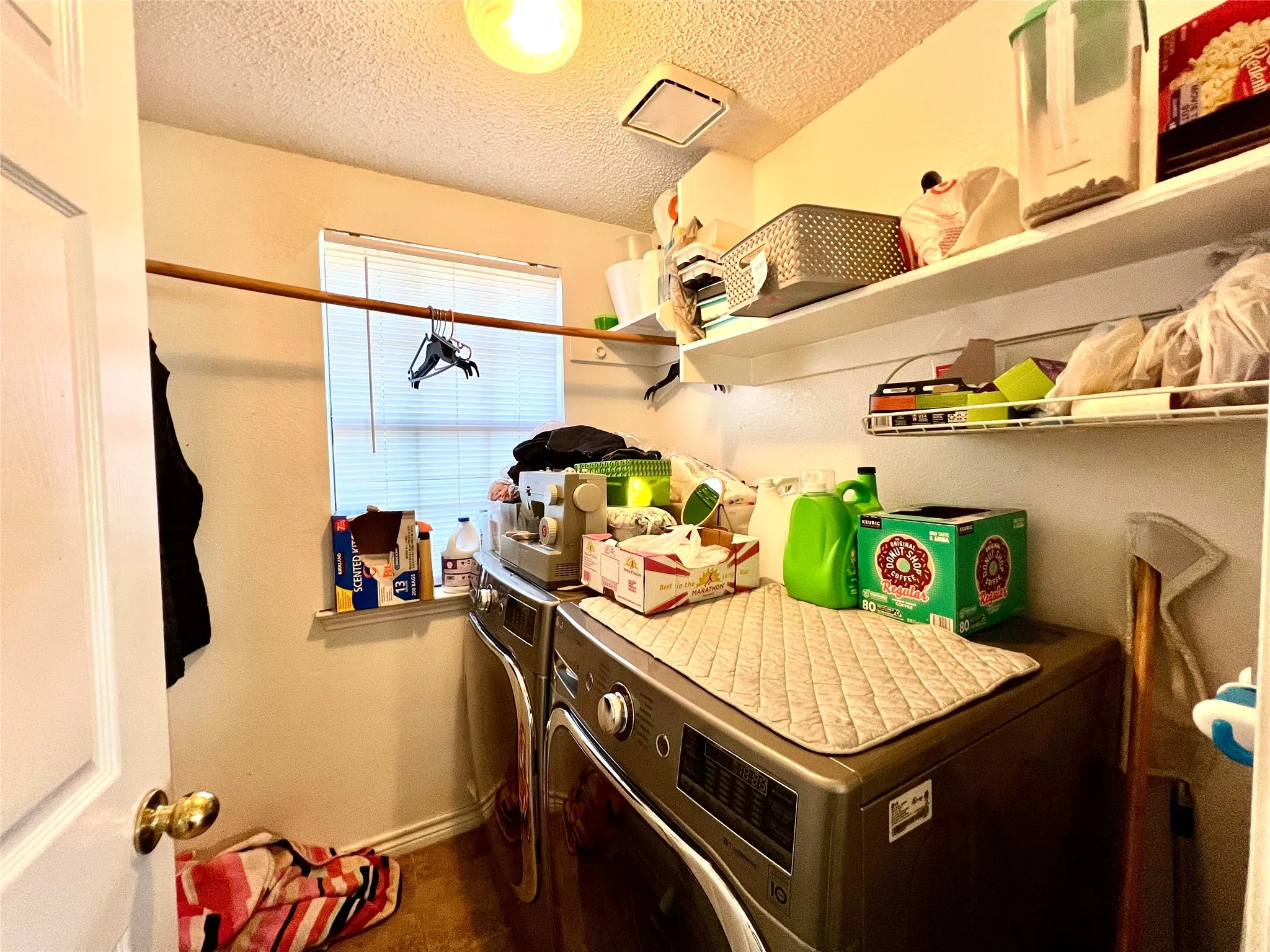 Washroom featuring washer and dryer and a textured ceiling