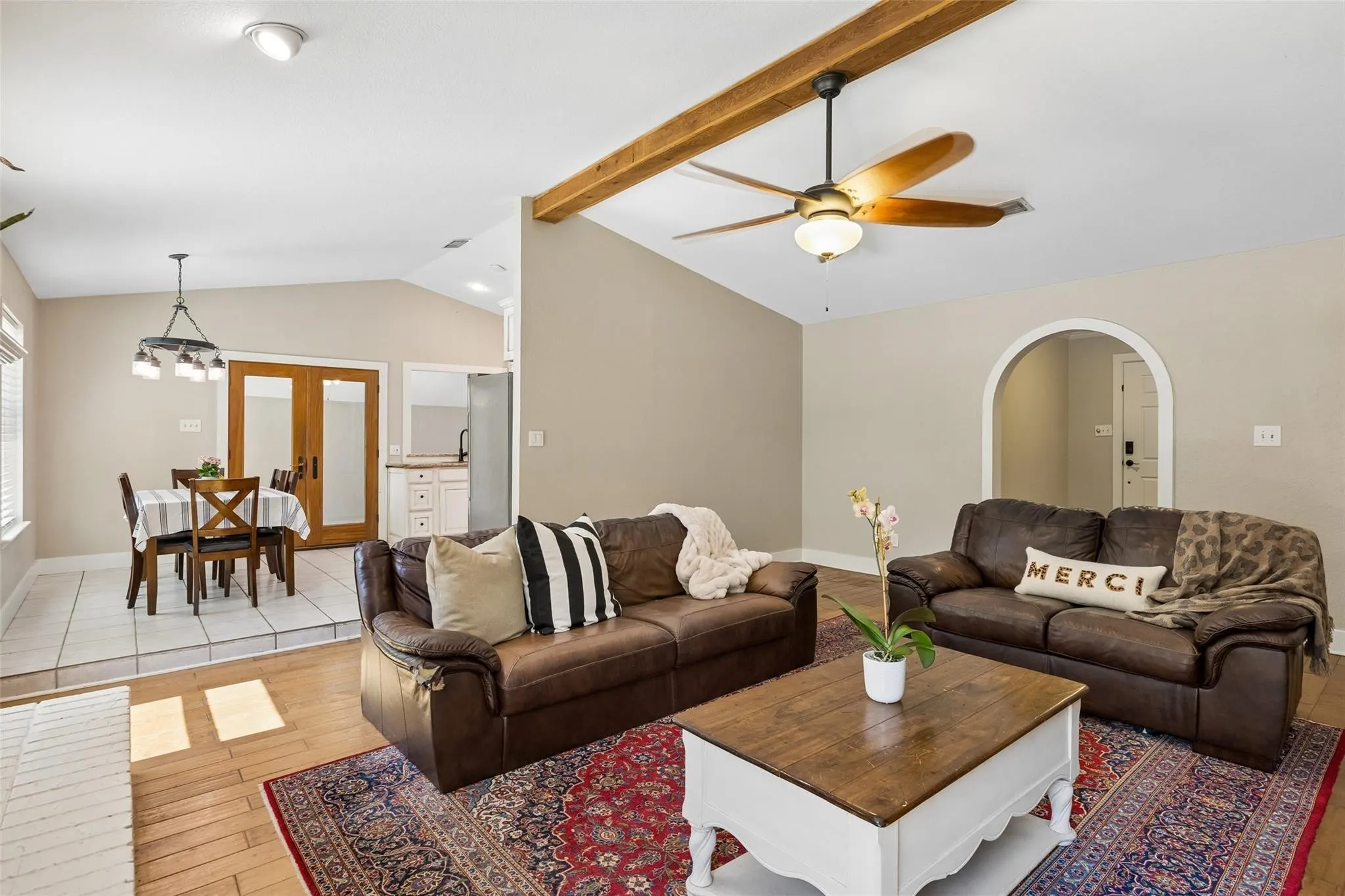 Vaulted ceiling with exposed wood beams and ceiling fan