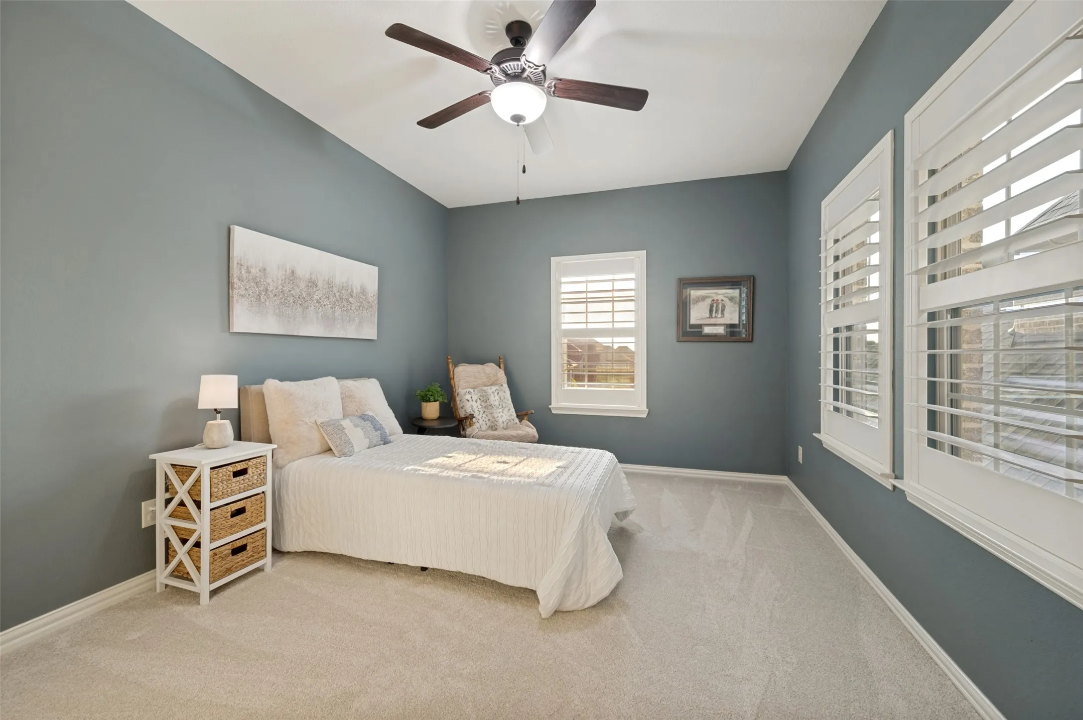 Another spacious secondary bedroom offers plenty of room to relax and unwind, featuring plush carpeting, plantation shutters, a walk-in closet and an abundance of natural light. The generous layout provides ample space for additional seating or furnishings, creating a comfortable and inviting private retreat.