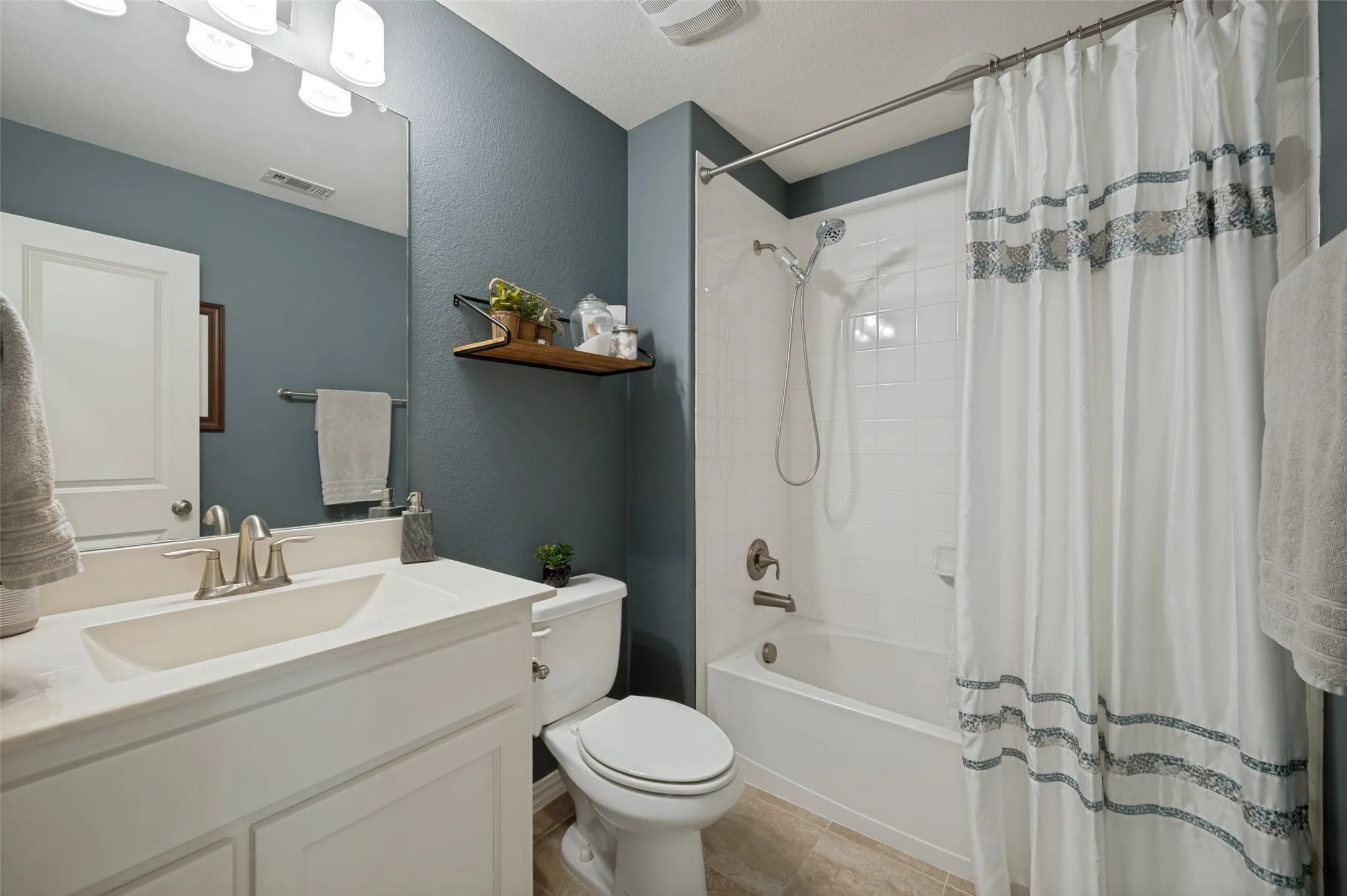 A bright and inviting upstairs guest bath offers both comfort and convenience with a spacious vanity, generous counter space, and a shower/tub combination. Clean finishes and a functional layout create a fresh, welcoming space for family members or overnight guests.
