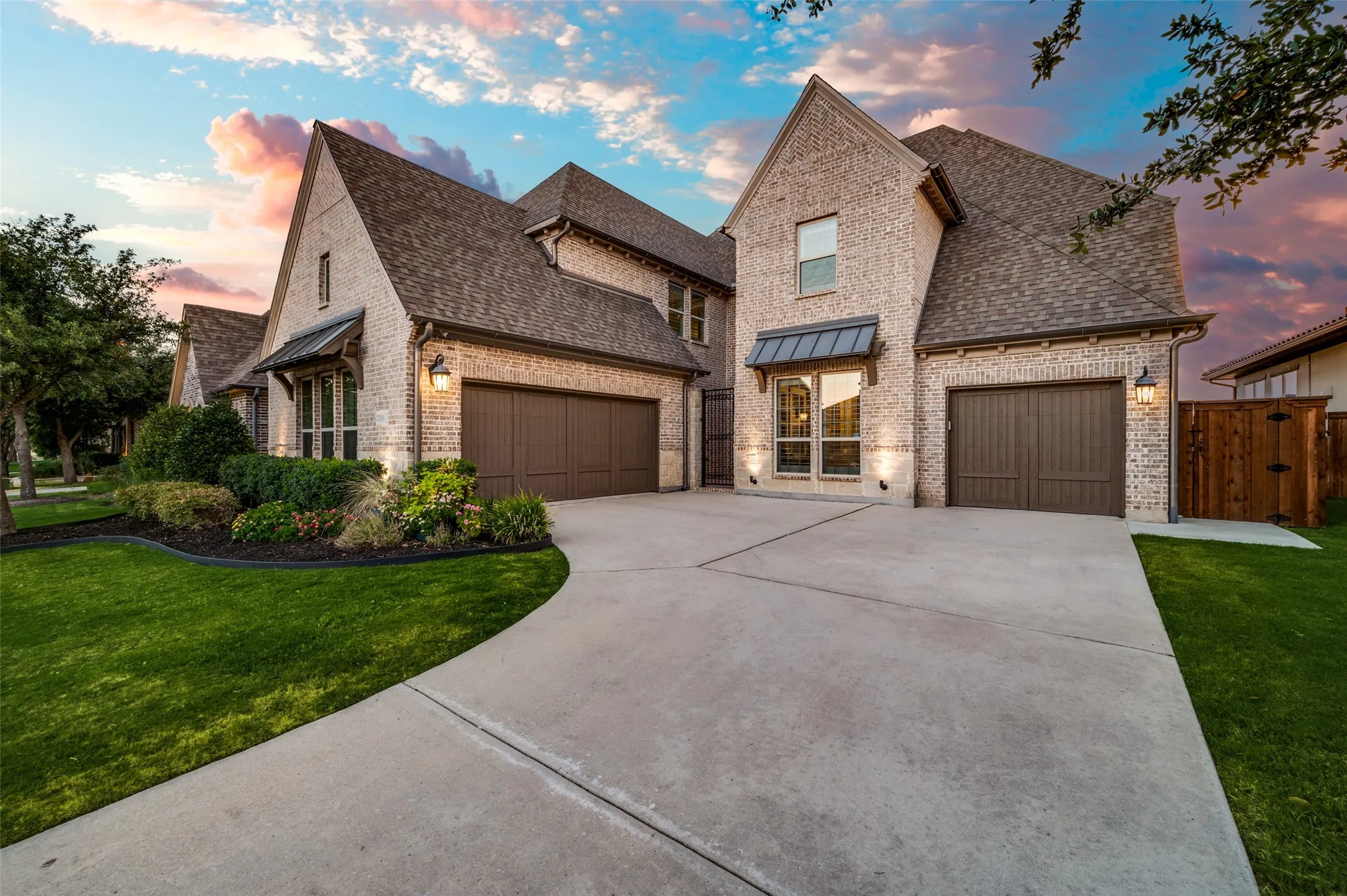 Lush landscaping, a manicured lawn, and elegant exterior lighting create a warm and inviting first impression while the spacious driveway and separate third-car garage provide ample parking, storage, and added convenience.