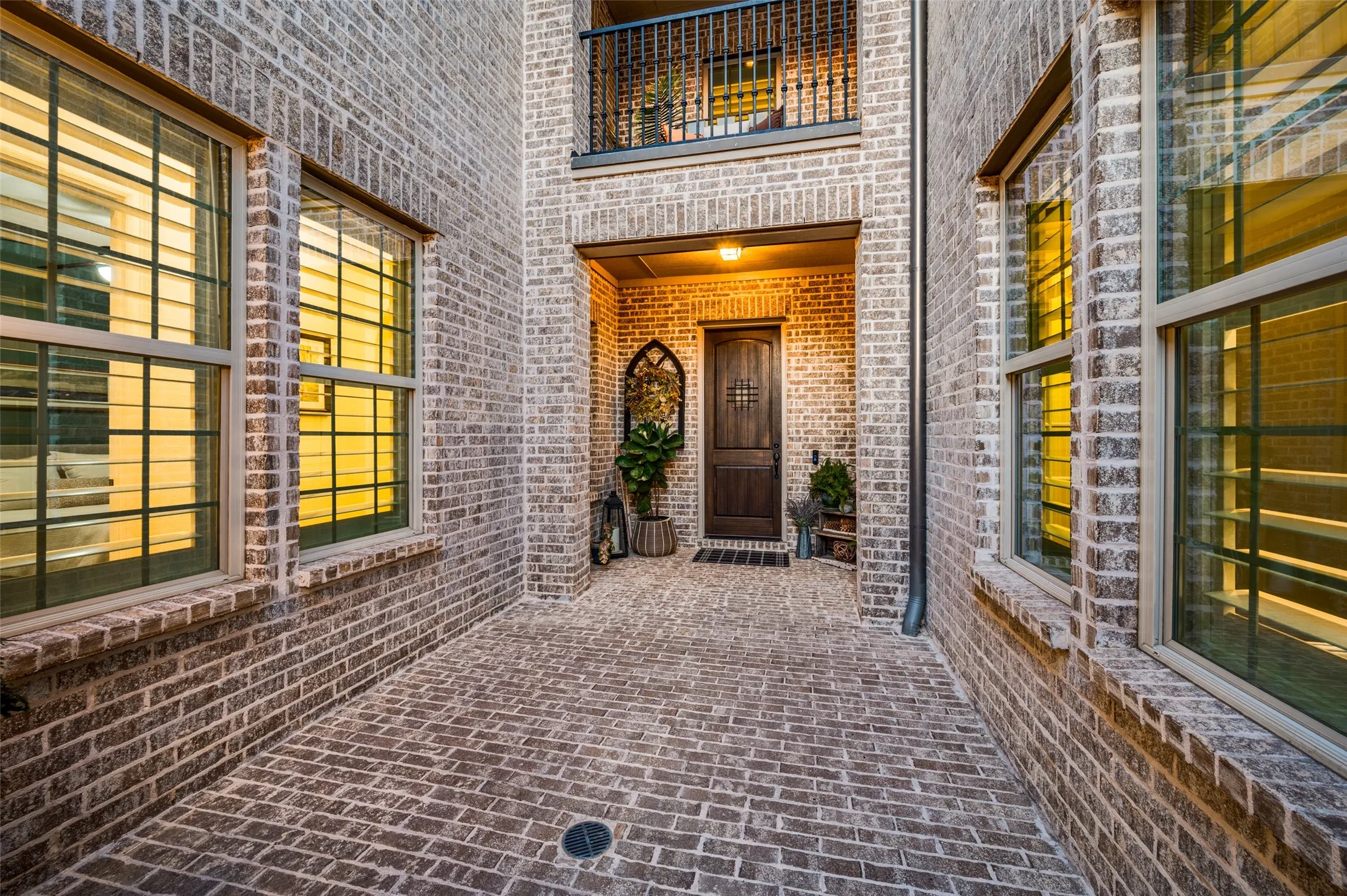 A charming courtyard-style entry creates a warm and elegant welcome. An overlooking terrace above the courtyard adds architectural interest and a distinctive touch, creating an impressive sense of arrival before you even step inside.