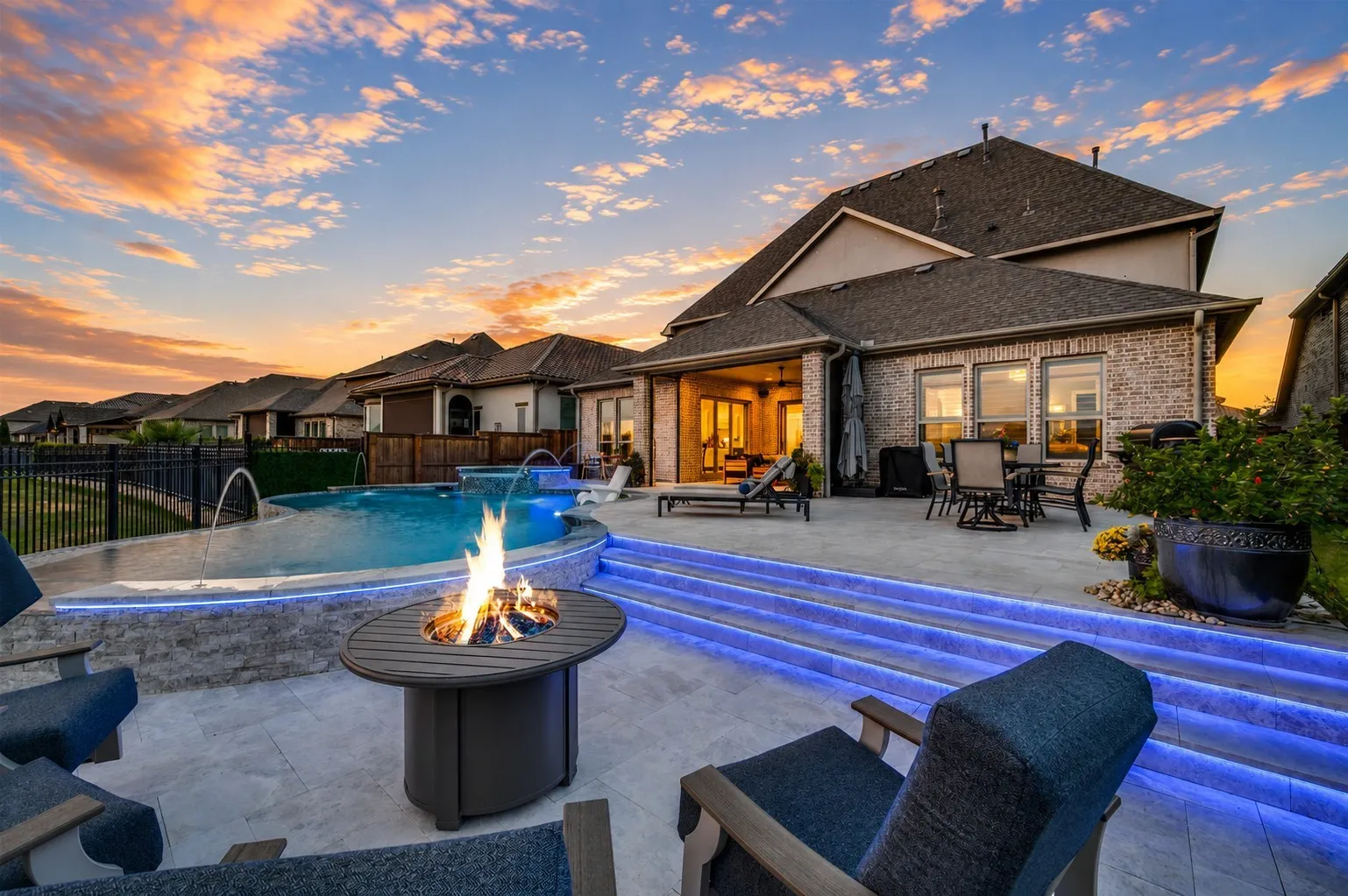 An exceptional backyard retreat designed for unforgettable entertaining, featuring a resort-style pool, dramatic water features, and striking accent lighting that transforms the space after sunset. Expansive patio areas provide multiple spaces for dining and lounging, while the cozy fire pit creates the perfect gathering spot. Breathtaking views complete this incredible outdoor oasis.