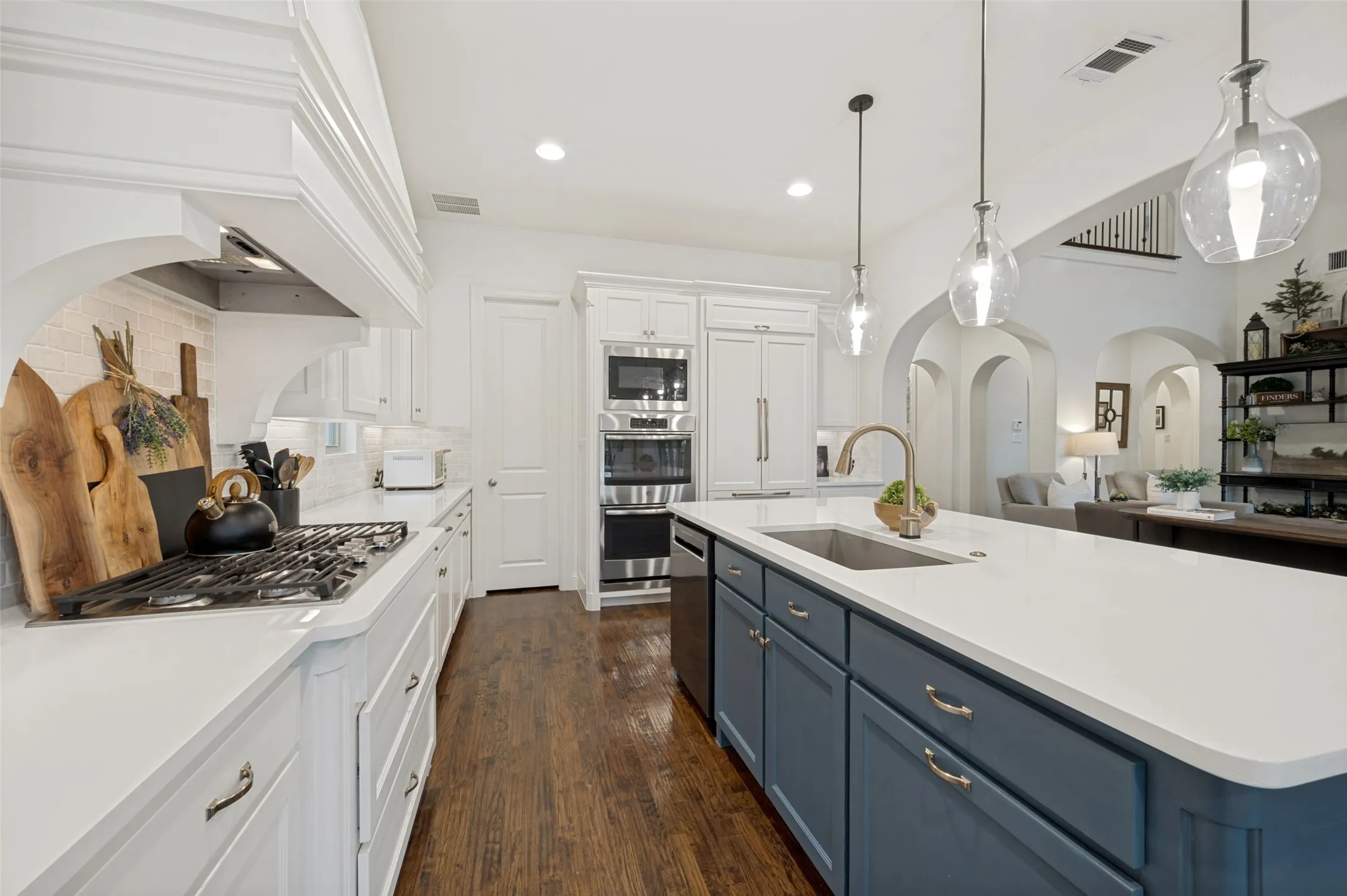 This stunning chef-inspired kitchen combines style and function with an oversized quartz island, abundant custom cabinetry, and beautiful hardwood floors. A gas cooktop, double oven, Sub-Zero refrigerator, and statement vent hood provide everything needed for the home chef, and generous counter space create the perfect setting for cooking, gathering, and entertaining.